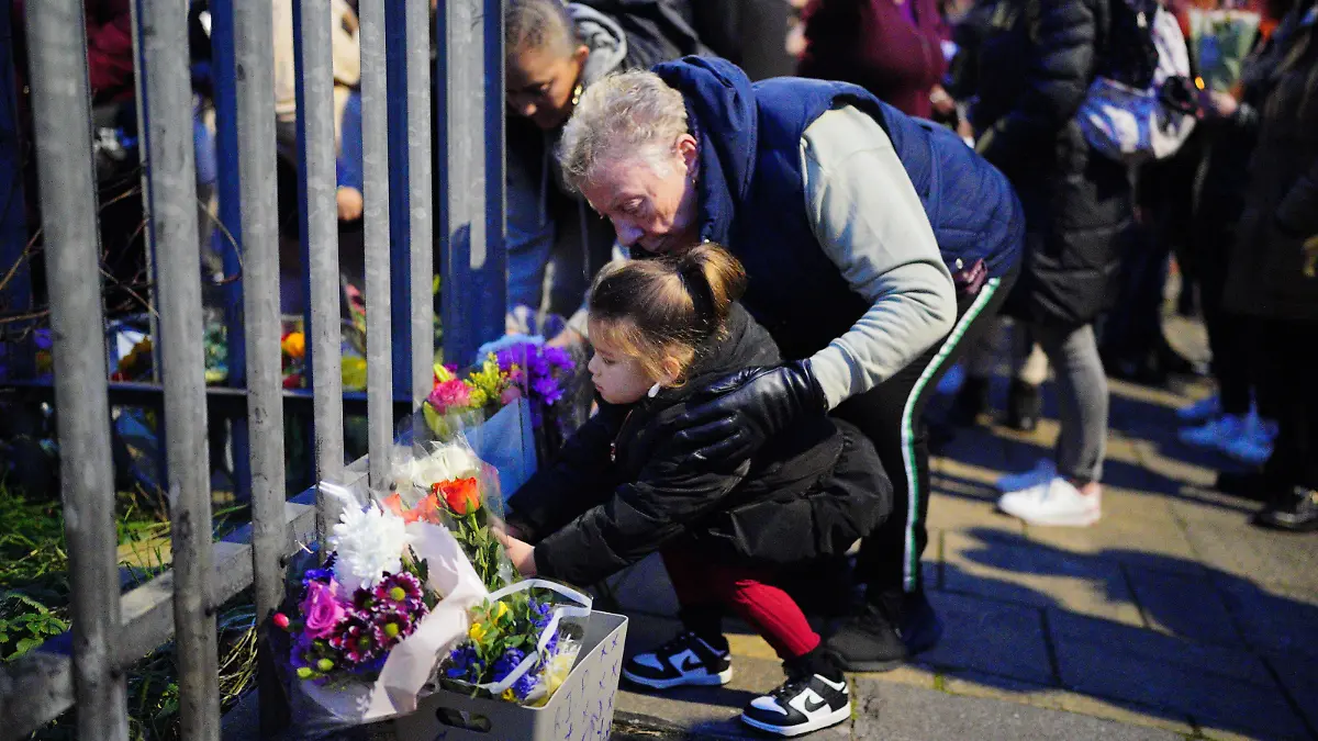 Bristol stabbing. EDITORS NOTE PARENTAL PERMISSION GIVEN A young girl lays flowers during a vigil near to the scene in south Bristol where two teenage boys, aged 15 and 16, died after a stabbing attack by a group of people who fled the scene in a car. Picture date: Sunday January 28, 2024. The two boys were attacked in Ilminster Avenue, in Knowle West, south Bristol, at about 11.20pm on Saturday, Avon and Somerset Police said. A 44-year-old man and a 15-year-old boy have been arrested and are in custody. See PA story POLICE Bristol. Photo credit should read: Ben Birchall/PA Wire URN:75180815