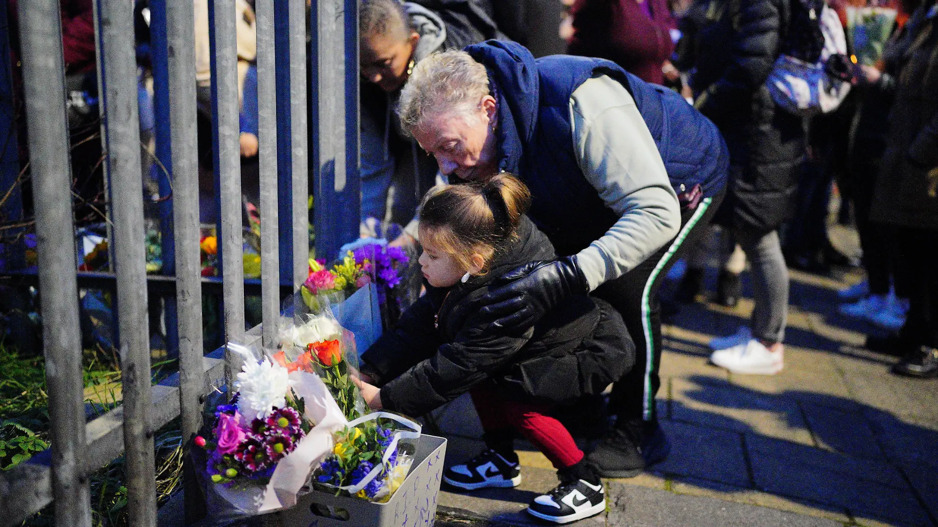 Bristol stabbing. EDITORS NOTE PARENTAL PERMISSION GIVEN A young girl lays flowers during a vigil near to the scene in south Bristol where two teenage boys, aged 15 and 16, died after a stabbing attack by a group of people who fled the scene in a car. Picture date: Sunday January 28, 2024. The two boys were attacked in Ilminster Avenue, in Knowle West, south Bristol, at about 11.20pm on Saturday, Avon and Somerset Police said. A 44-year-old man and a 15-year-old boy have been arrested and are in custody. See PA story POLICE Bristol. Photo credit should read: Ben Birchall/PA Wire URN:75180815