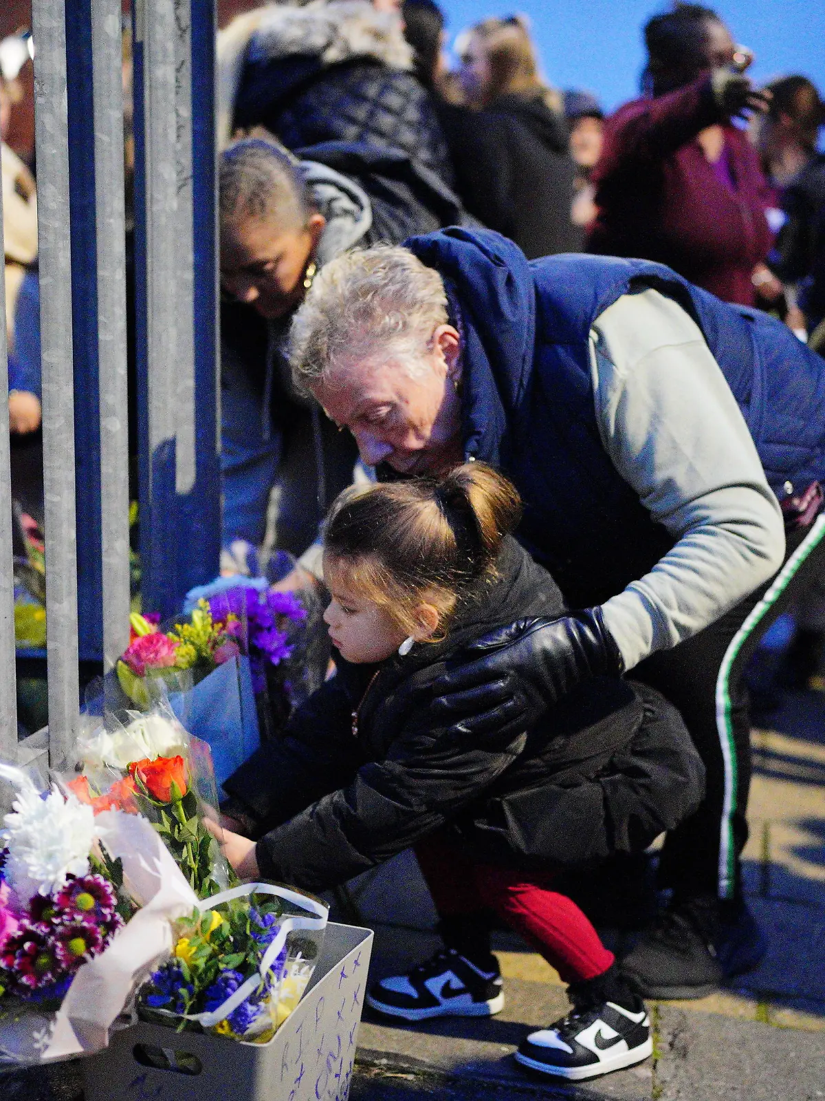 Bristol stabbing. EDITORS NOTE PARENTAL PERMISSION GIVEN A young girl lays flowers during a vigil near to the scene in south Bristol where two teenage boys, aged 15 and 16, died after a stabbing attack by a group of people who fled the scene in a car. Picture date: Sunday January 28, 2024. The two boys were attacked in Ilminster Avenue, in Knowle West, south Bristol, at about 11.20pm on Saturday, Avon and Somerset Police said. A 44-year-old man and a 15-year-old boy have been arrested and are in custody. See PA story POLICE Bristol. Photo credit should read: Ben Birchall/PA Wire URN:75180815