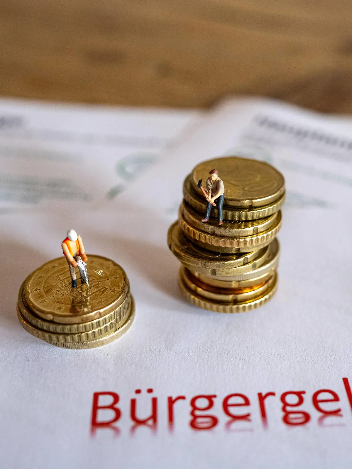 Feature Bürgergeld 2024 02.01.2024, Limburg: Symbolfoto, Illustrationsbild, Symbolbild, Illustrationsfoto Das neue Kapitel im sozialen Netz: Erhöhung des Bürgergeldes ab dem 1. Januar 2024. Das Bild zeigt symbolische Antragsformulare für das Bürgergeld sowie Geldmünzen und symbolische Spielzeugfiguren in Form von Bauarbeitern. Seit dem Jahreswechsel erhalten Bedürftige 12% mehr Bürgergeld, vormals Hartz IV. Limburg Hessen Germany *** Feature Citizens Income 2024 02 01 2024, Limburg Symbol photo, illustration image, symbol image, illustration photo The new chapter in the social safety net Increase in the Citizens Income from January 1, 2024 The image shows symbolic application forms for the Citizens Income as well as coins and sy
