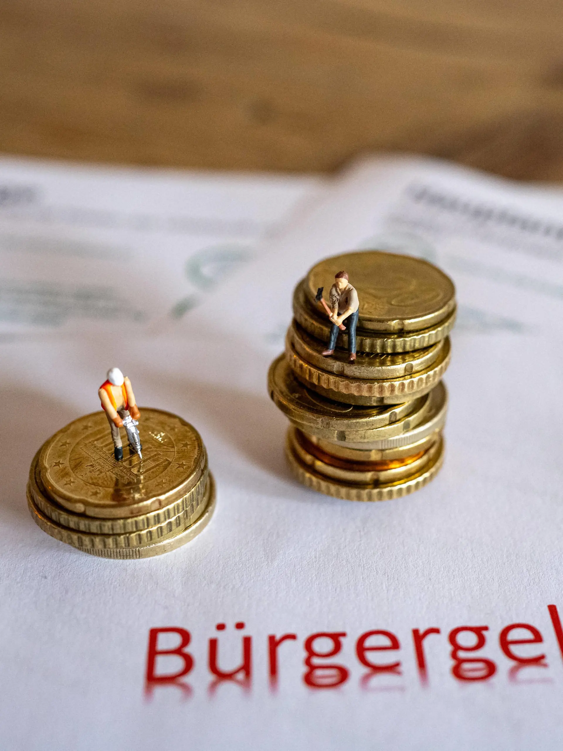 Feature Bürgergeld 2024 02.01.2024, Limburg: Symbolfoto, Illustrationsbild, Symbolbild, Illustrationsfoto Das neue Kapitel im sozialen Netz: Erhöhung des Bürgergeldes ab dem 1. Januar 2024. Das Bild zeigt symbolische Antragsformulare für das Bürgergeld sowie Geldmünzen und symbolische Spielzeugfiguren in Form von Bauarbeitern. Seit dem Jahreswechsel erhalten Bedürftige 12% mehr Bürgergeld, vormals Hartz IV. Limburg Hessen Germany *** Feature Citizens Income 2024 02 01 2024, Limburg Symbol photo, illustration image, symbol image, illustration photo The new chapter in the social safety net Increase in the Citizens Income from January 1, 2024 The image shows symbolic application forms for the Citizens Income as well as coins and sy