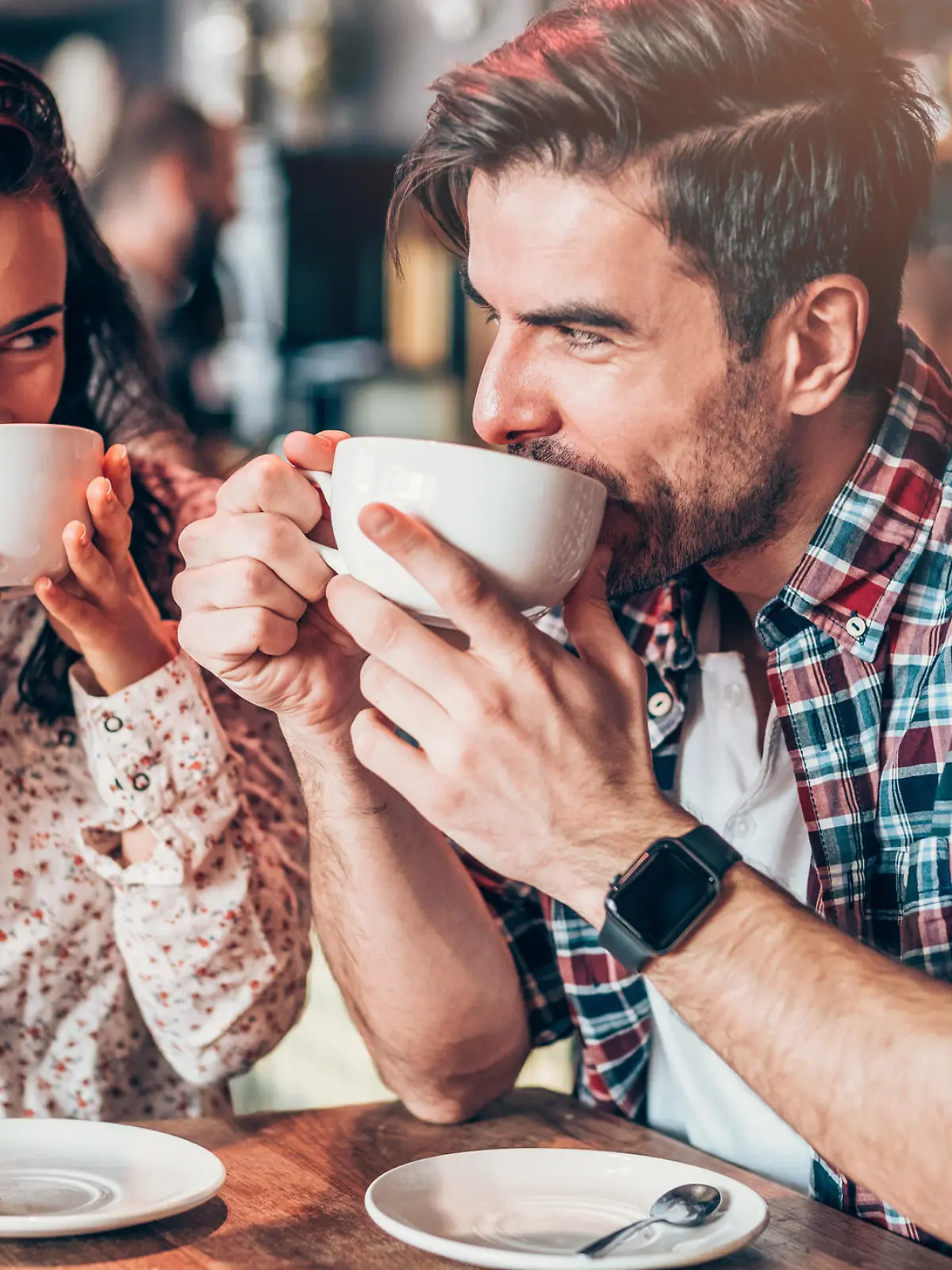 Beautiful young couple drinking coffee and looking each other