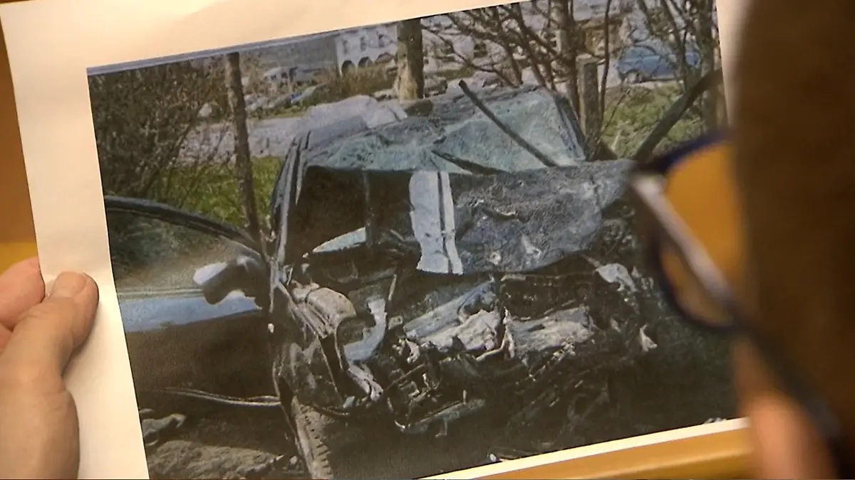 Manuel Wehner schaut sich ein Fotos seines Auto-Wracks an.