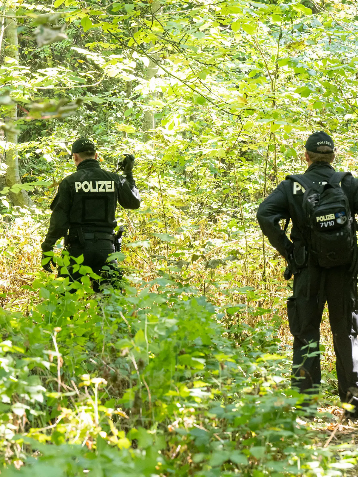 ARCHIV - 23.08.2022, Bayern, Ingolstadt: Polizisten durchsuchen ein Waldstück nach Spuren und Gegenständen. In der Nähe war am 16.08.2022 eine weibliche Leiche in einem Auto entdeckt worden. Der Fall wird ab 16. Januar in einem aufwendigen Mordprozess am Landgericht Ingolstadt verhandelt. Einer jungen Frau wird in dem Prozess vorgeworfen, dass sie untertauchen und ihren Tod vortäuschen wollte. Deswegen soll sie über ein soziales Netzwerk Kontakt zu einer Frau in Baden-Württemberg, die ihr ähnlich sieht, aufgenommen haben. Dann soll sie die Doppelgängerin gemeinsam mit einem Bekannten getötet haben.     (zu dpa «Gericht verhandelt mehrere Monate Prozess um Mord an Doppelgängerin») Foto: Peter Kneffel/dpa +++ dpa-Bildfunk +++