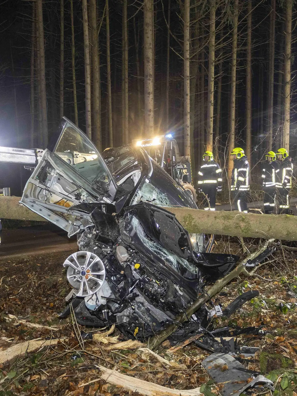 29.01.2024, Österreich, Aurolzmünster: Feuerwehrleute stehen um ein Auto herum, das von einem Baumstamm durchbohrt im Wald liegt. Bei einem Verkehrsunfall in Österreich ist das Auto einer Lenkerin von einem Baum gepfählt worden. Die 27-jährige Frau überlebte jedoch und konnte sich selbstständig aus ihrem Fahrzeug befreien, wie die Polizei am Dienstag mitteilte. Die Frau war am Vorabend bei Weilbach in Oberösterreich in einem Wald von der Straße abgekommen. Foto: Daniel Scharinger/APA/dpa +++ dpa-Bildfunk +++