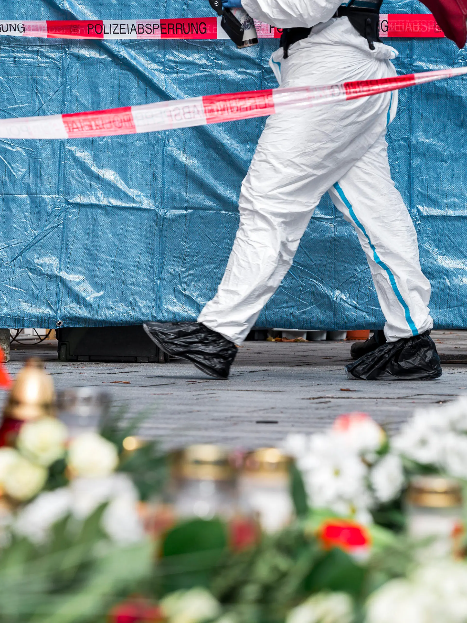ARCHIV - 13.03.2023, Bayern, Lichtenfels: Ein Mitarbeiter der Spurensicherung geht in den abgesperrten Bereich vor dem Blumengeschäft, in dem eine leblose Frau aufgefunden wurde. Spaziergänger hatten die tote 50-Jährige in dem Blumenladen in der Lichtenfelser Innenstadt entdeckt. Für den Mord an einer Blumenverkäuferin in Oberfranken ist ein 18-Jähriger zu einer Jugendstrafe von neuneinhalb Jahren verurteilt worden. (zu dpa: «Neuneinhalbjahre Jugendstrafe für Mord an Blumenverkäuferin») Foto: Daniel Vogl/dpa +++ dpa-Bildfunk +++