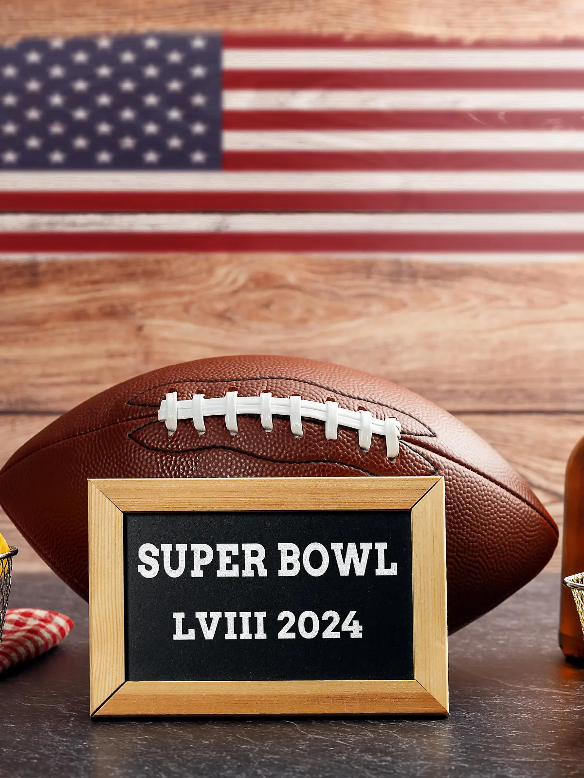 January 27, 2024: The 58th Super Bowl, football surrounded by snacks and beer and USA flag with a plaque reading Super Bowl LVIII 2024 PHOTO MONTAGE *** Der 58. Super Bowl, Football umgeben von Snacks und Bier und USA Flagge mit einer Tafel mit der Aufschrift Super Bowl LVIII 2024 FOTOMONTAGE