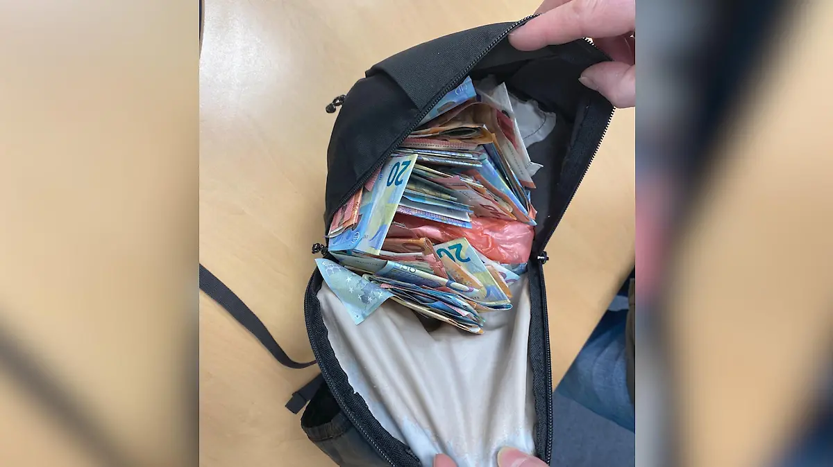 Eine Bauchtasche mit vielen Geldscheinen drin.