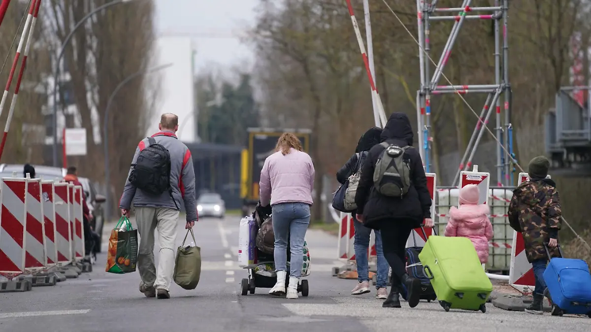 ARCHIV - 14.03.2022, Hamburg: Ukrainische Flüchtlinge verlassen mit ihrem Gepäck die Flüchtlingsunterkunft im ehemaligen Fegro Großmarkt im Stadtteil Harburg (zu dpa «Große Hilfe: 160 000 bieten Unterkunft für Ukraine-Geflüchtete»). Foto: Marcus Brandt/dpa +++ dpa-Bildfunk +++