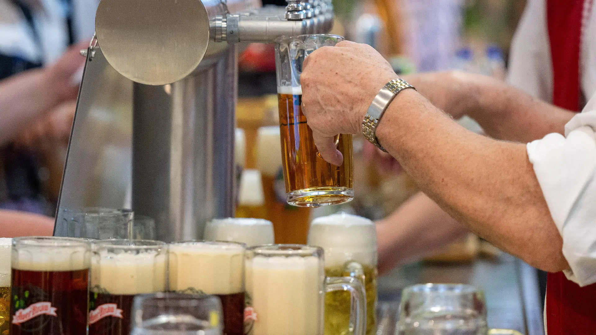 ARCHIV - 22.01.2024, Berlin: Ein Mann gießt Bier vom Zapfhahn ins Glas in einer Ausstellungshalle auf der Grünen Woche. (zu dpa: «Das Bier läuft nicht mehr - Brauereien in der Zange») Foto: Monika Skolimowska/dpa +++ dpa-Bildfunk +++
