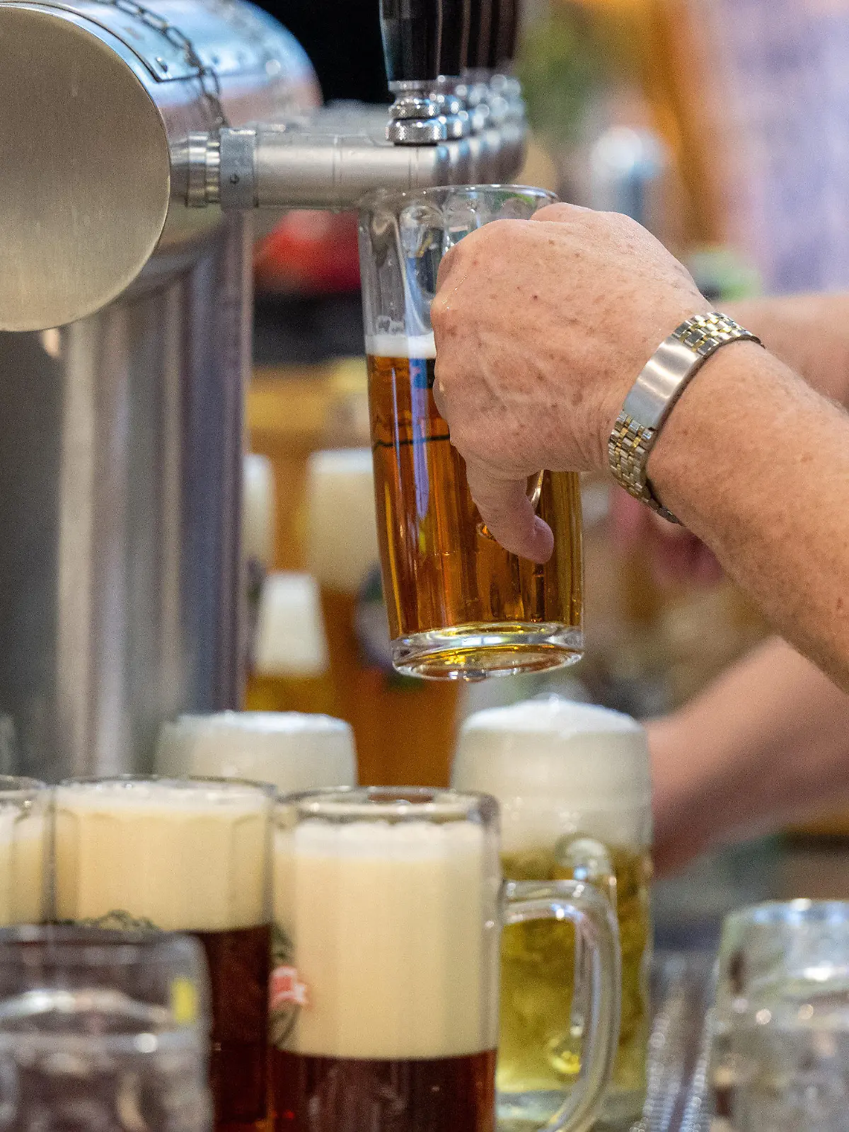 ARCHIV - 22.01.2024, Berlin: Ein Mann gießt Bier vom Zapfhahn ins Glas in einer Ausstellungshalle auf der Grünen Woche.  (zu dpa: «Das Bier läuft nicht mehr - Brauereien in der Zange») Foto: Monika Skolimowska/dpa +++ dpa-Bildfunk +++