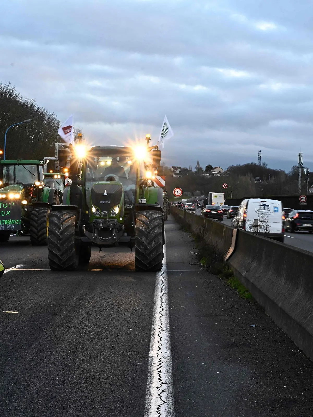 30.01.2024, Frankreich, Longjumeau: Französische Landwirte fahren Traktoren in Richtung des Lebensmittelgroßmarkts von Rungis, nachdem sie eine Straßensperre der Polizei umgangen haben. Im Kampf für bessere Arbeits- und Lebensbedingungen haben französische Landwirte ihre Blockade von Autobahnen rund um Paris am Dienstag fortgesetzt. Foto: Julien De Rosa/AFP/dpa +++ dpa-Bildfunk +++
