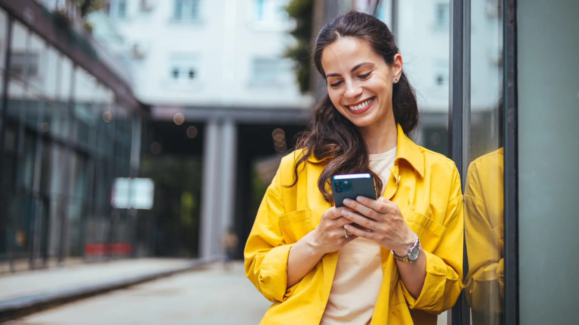 Shot of a beautiful mature businesswoman texting. Mature businesswoman walking outdoors and using cellphone. Female business professional walking outside and texting from her mobile phone.