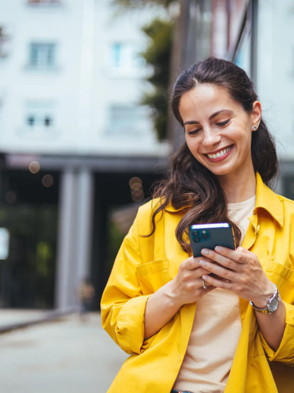 Shot of a beautiful mature businesswoman texting. Mature businesswoman walking outdoors and using cellphone. Female business professional walking outside and texting from her mobile phone.