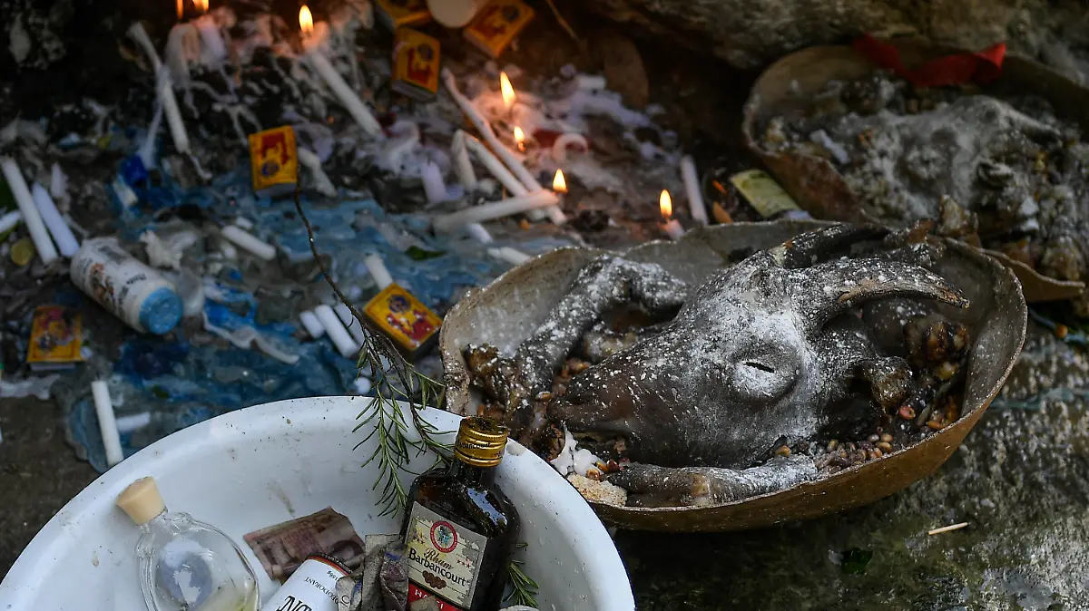The head of a goat sits on an altar next to a waterfall believed to have purifying powers during an annual celebration marking the feast day of Our Lady of Mount Carmel, in Saut d' Eau, Haiti, Friday, July 16, 2021. The annual pilgrimage is made in honor of Haiti's most celebrated patron saint, Our Lady of Mount Carmel, who is supposed to have appeared on a palm tree in 1847 in the Palm Grove in Saut d'Eau and was integrated into Haiti's voodoo culture as the goddess of love. (AP Photo/Matias Delacroix)