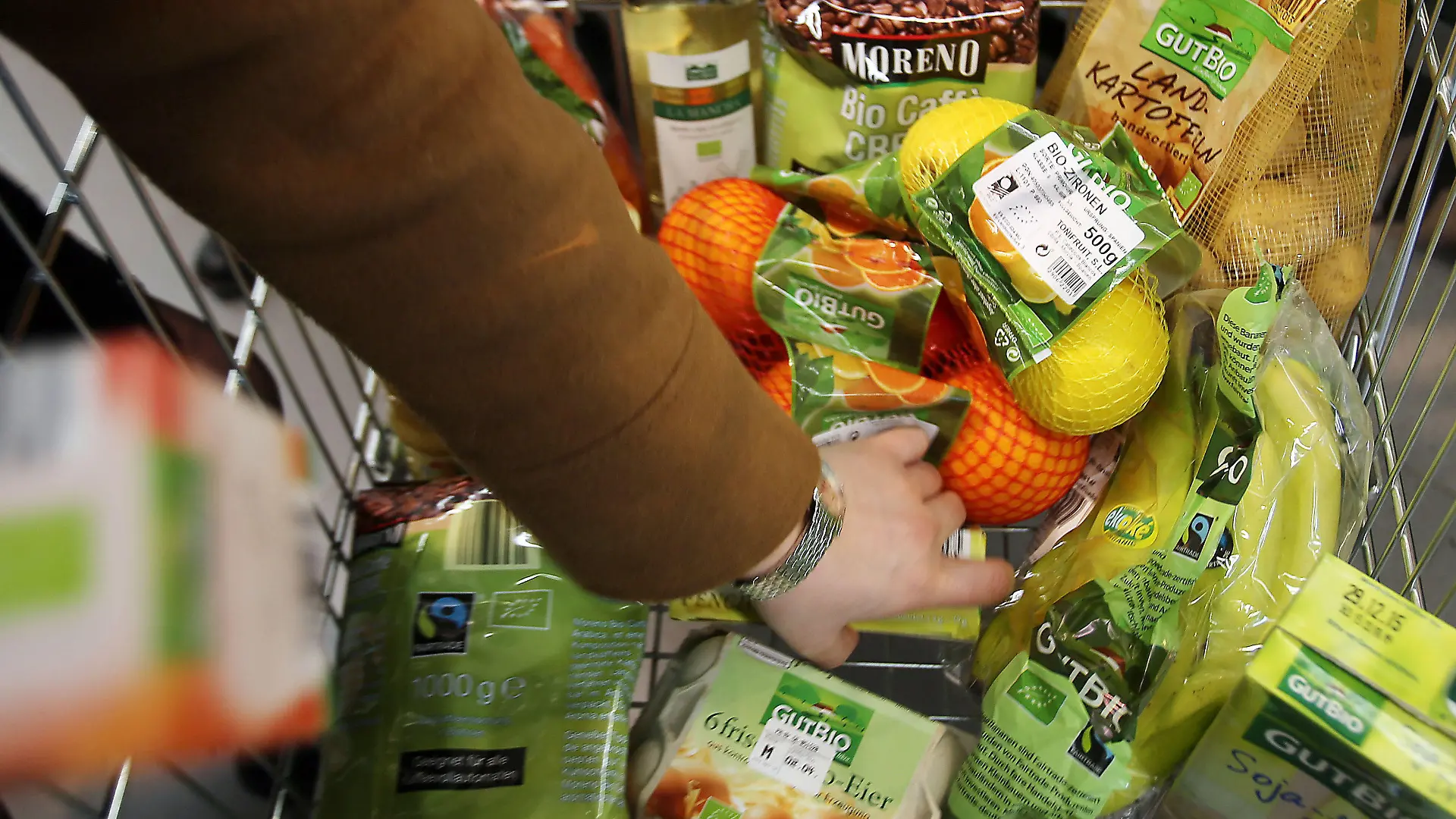 Eine Kundin legt am 13.03.2015 in Velbert (Nordrhein-Westfalen) in einem Supermarkt von Aldi (Nord) Bio-Produkte in den Einkaufswagen. Der Discounter vergrößert in diesen Wochen sein Bio-Sortiment drastisch. Unter der Eigenmarke «GutBio» sollen künftig über 50 Artikel aus kontrolliert ökologischem Anbau angeboten werden. Foto: Oliver Berg/dpa (zu dpa/lnw: "Darf es etwas mehr sein: Bioprodukte werden immer beliebter" vom 16.03.2015) +++(c) dpa - Bildfunk+++