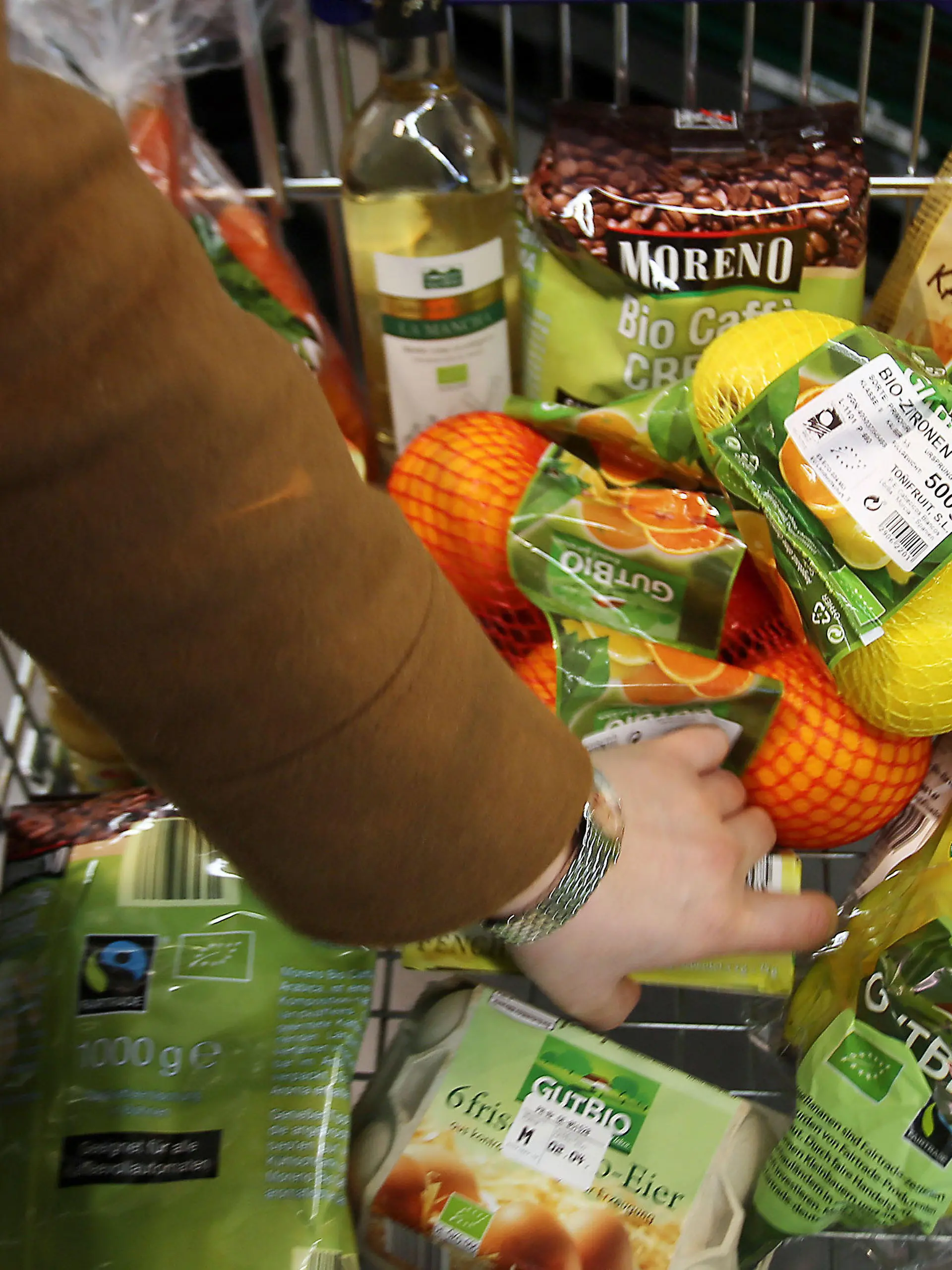 Eine Kundin legt am 13.03.2015 in Velbert (Nordrhein-Westfalen) in einem Supermarkt von Aldi (Nord) Bio-Produkte in den Einkaufswagen. Der Discounter vergrößert in diesen Wochen sein Bio-Sortiment drastisch. Unter der Eigenmarke «GutBio» sollen künftig über 50 Artikel aus kontrolliert ökologischem Anbau angeboten werden. Foto: Oliver Berg/dpa (zu dpa/lnw: "Darf es etwas mehr sein: Bioprodukte werden immer beliebter" vom 16.03.2015) +++(c) dpa - Bildfunk+++