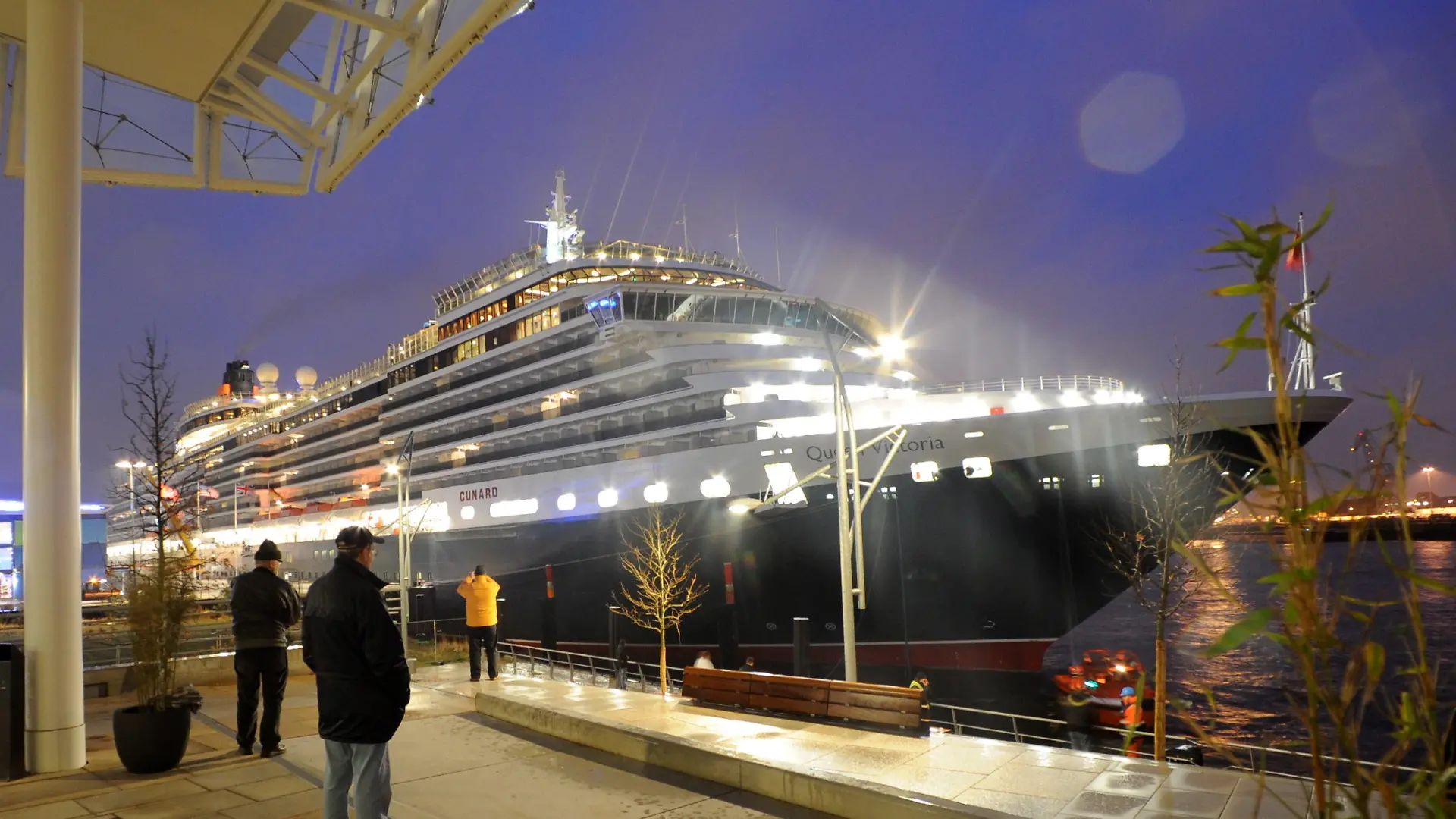 Passanten bestaunen am Freitagmorgen (11.12.2009) das Luxuskreuzfahrtschiff "Queen Victoria" am Kreuzfahrtterminal im Hamburger Hafen. Die "Queen Victoria" der Reederei Cunard ist das erste von fünf großen Kreuzfahrtschiffen, die vor Weihnachten im Grasbrookhafen in der Hafencity anlegen. Foto: Wolfgang Zabel dpa/lno +++(c) dpa - Bildfunk+++