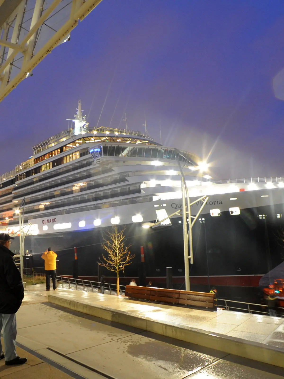 Passanten bestaunen am Freitagmorgen (11.12.2009) das Luxuskreuzfahrtschiff "Queen Victoria" am Kreuzfahrtterminal im Hamburger Hafen. Die "Queen Victoria" der Reederei Cunard ist das erste von fünf großen Kreuzfahrtschiffen, die vor Weihnachten im Grasbrookhafen in der Hafencity anlegen. Foto: Wolfgang Zabel dpa/lno  +++(c) dpa - Bildfunk+++