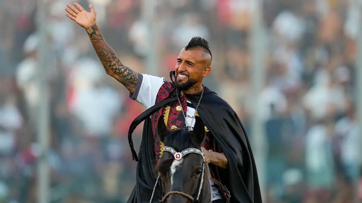 01.02.2024, Chile, Santiago: Arturo Vidal, Fußballspieler aus Chile, winkt den Fans, während er zu seiner Begrüßungszeremonie im Monumentalstadion auf einem Pferd auf das Spielfeld reitet. Der frühere Bundesliga-Profi Vidal kehrt nach 17 Jahren zu seinem Jugendverein Colo-Colo zurück. Foto: Esteban Felix/AP/dpa +++ dpa-Bildfunk +++