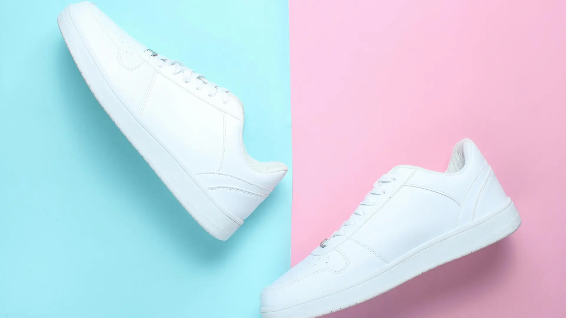 Weiße Sneaker vor pinkem und blauem Hintegrund.