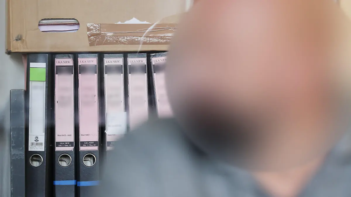 20.07.2023, Nordrhein-Westfalen, Duisburg: Der Angeklagte sitzt im Duisburger Landgericht bei seinem Prozess vor seinen Gerichtsakten. In Duisburg hat ein Strafprozess gegen den früheren Vorstandsvorsitzenden eines Vereins begonnen, der fast 700.000 Euro für private Reisen und Luxusgüter veruntreut haben soll. Foto: David Young/dpa - ACHTUNG: die Person wurde aus rechtlichen Gründen gepixelt +++ dpa-Bildfunk +++