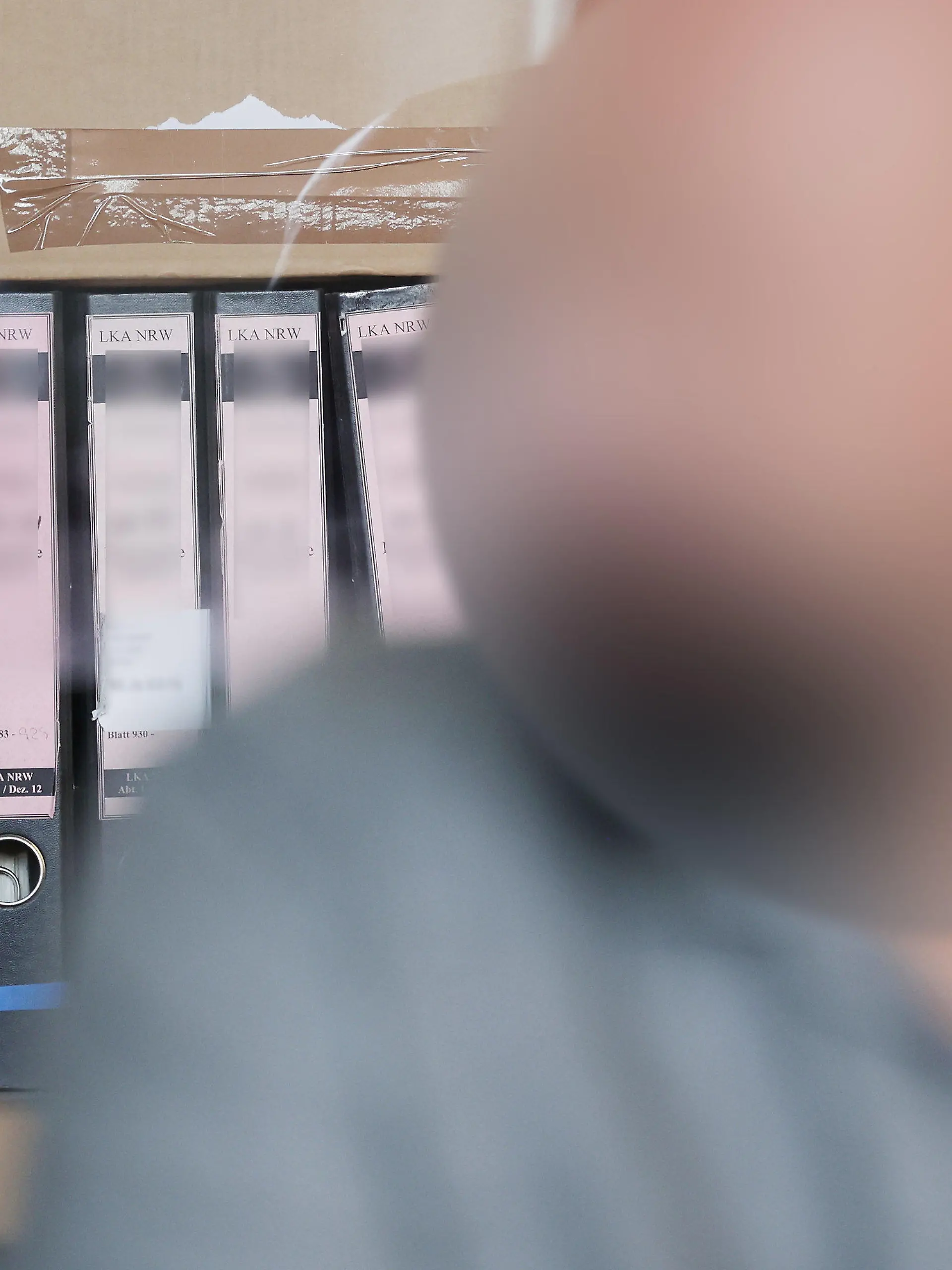 20.07.2023, Nordrhein-Westfalen, Duisburg: Der Angeklagte sitzt im Duisburger Landgericht bei seinem Prozess vor seinen Gerichtsakten. In Duisburg hat ein Strafprozess gegen den früheren Vorstandsvorsitzenden eines Vereins begonnen, der fast 700.000 Euro für private Reisen und Luxusgüter veruntreut haben soll. Foto: David Young/dpa - ACHTUNG: die Person wurde aus rechtlichen Gründen gepixelt +++ dpa-Bildfunk +++