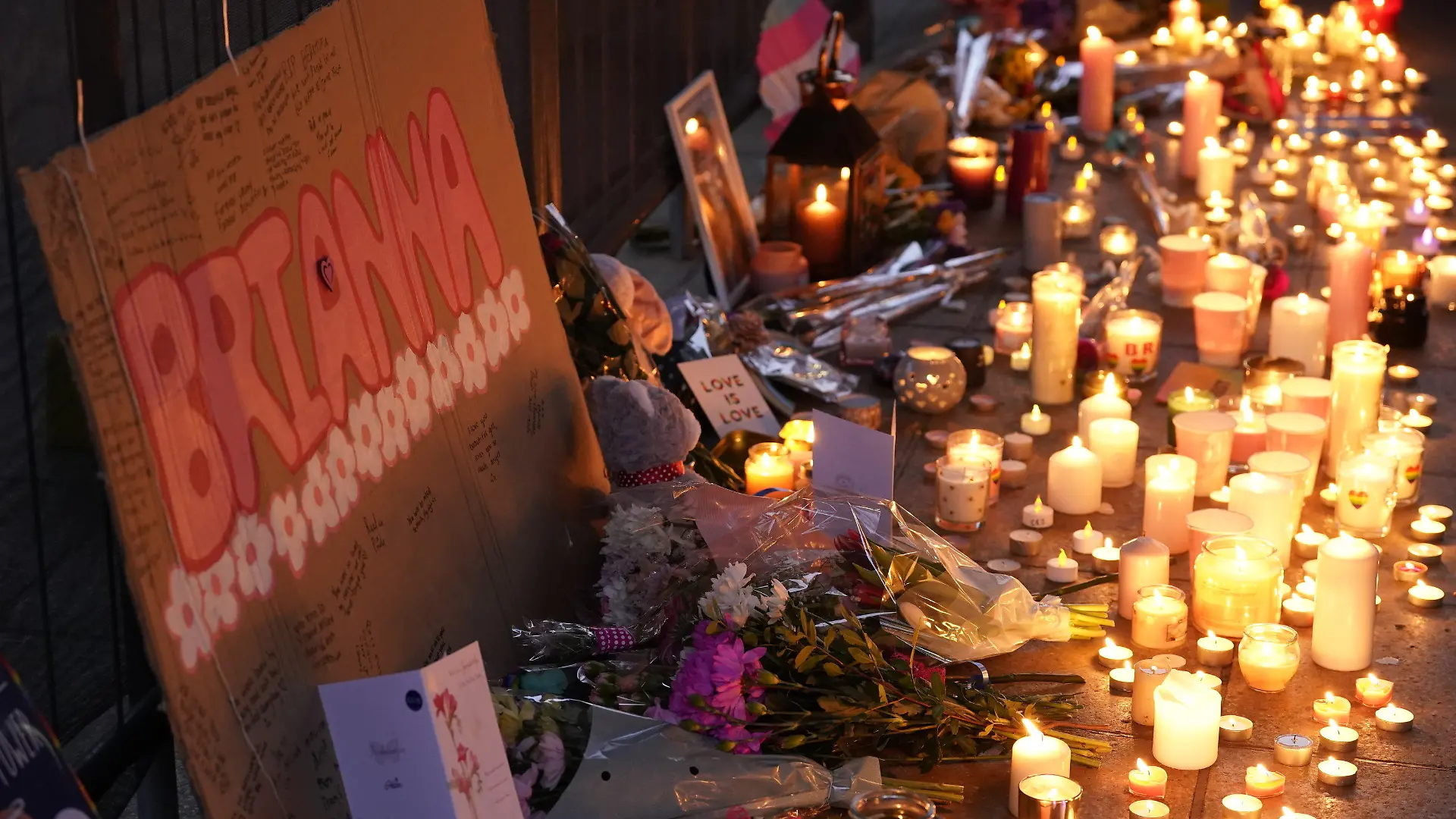 ARCHIV - 18.02.2023, Großbritannien, Warrington: Blumen und Kerzen liegen während einer Mahnwache am Old Market Place zum Gedenken an die transsexuelle Jugendliche Brianna Ghey. Die 16-Jährige war am vergangenen Wochenende erstochen worden. Zwei Jugendliche - ein Mädchen und ein Junge im Alter von je 15 Jahren - sind wegen Mordes angeklagt. Die Polizei geht bislang nicht von Hasskriminalität im Zusammenhang mit ihrer Geschlechtsidentität aus. (zu dpa: «Lebenslange Haft für Mord an Transgender-Teenager in Großbritannien») Foto: Danny Lawson/PA Wire/dpa +++ dpa-Bildfunk +++