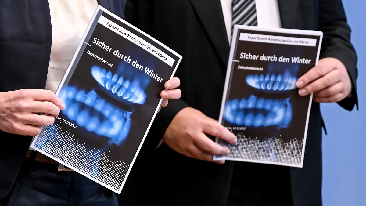 10.10.2022, Berlin: Teilnehmer der Pressekonferenz zum Zwischenbericht der Kommission Erdgas und Wärme halten den Bericht in ihren Händen. Die Ampelkoalition hat angekündigt, Verbraucher und Unternehmen wegen der steigenden Energiepreise zu unterstützen. Foto: Britta Pedersen/dpa +++ dpa-Bildfunk +++