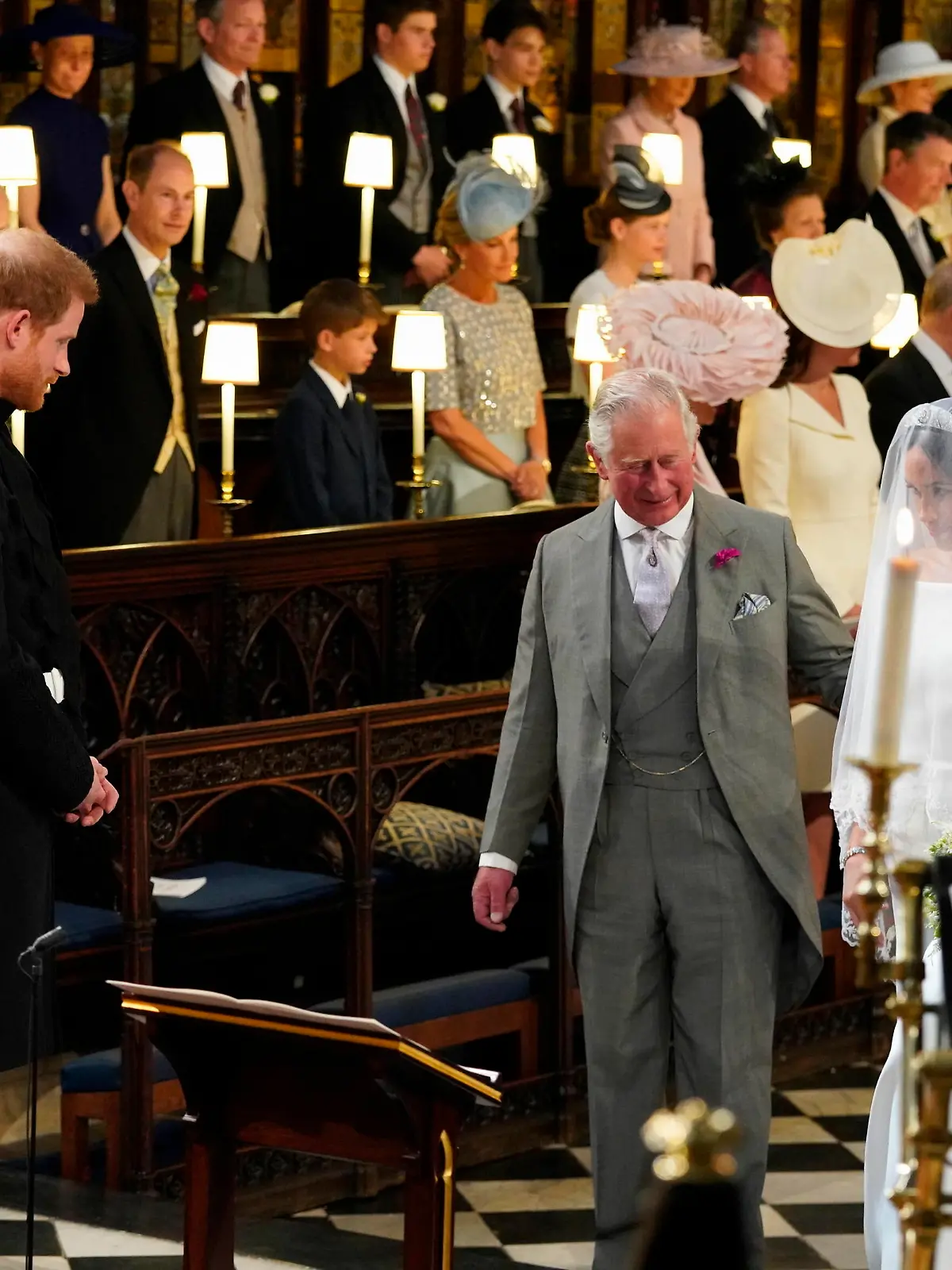 Prince Harry looks at his bride, Meghan Markle, as she arrives accompanied by the Prince of Wales in St George's Chapel at Windsor Castle for their wedding.