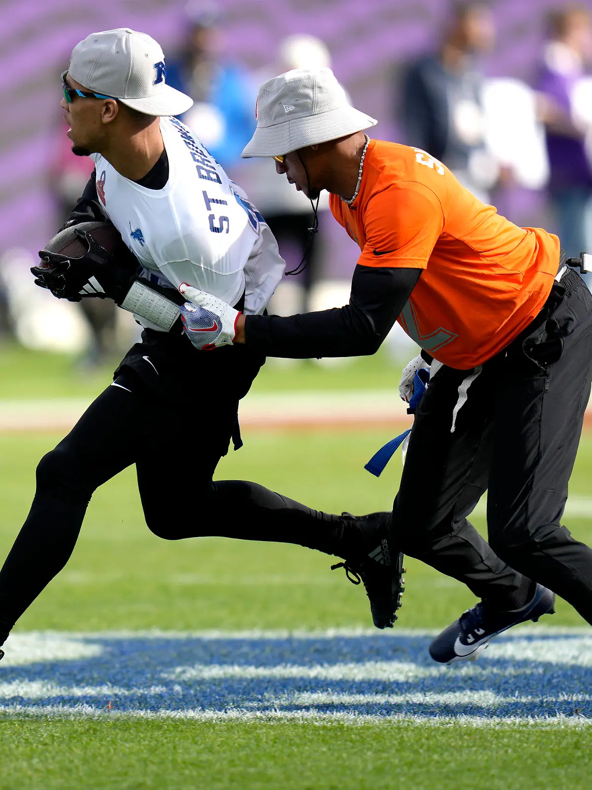 NFC Amon-Ra St. Brown, of the Detroit Lions, is stopped by AFC cornerback Pat Surtain II, of the Denver Broncos, right, during the flag football event at the NFL Pro Bowl football game, Sunday, Feb. 4, 2024, in Orlando. (AP Photo/John Raoux)