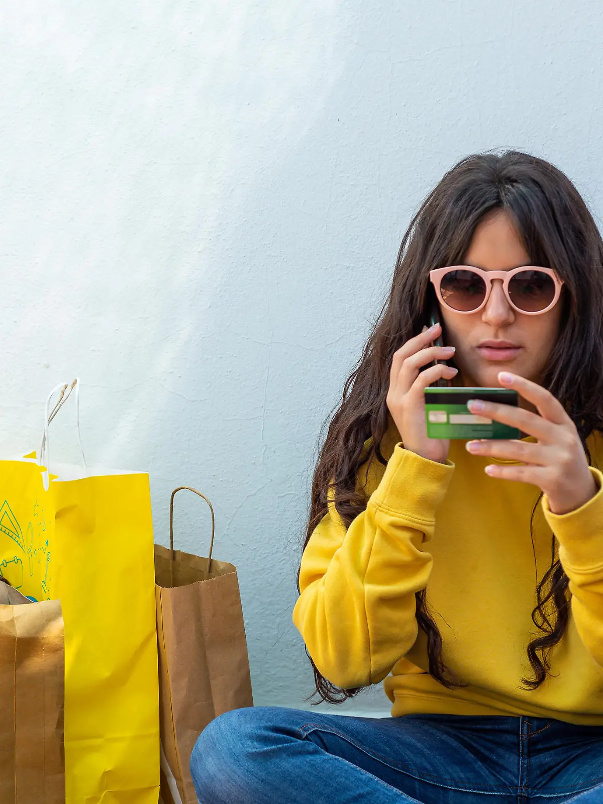 young girl holding a credit card and using a smartphone to make a purchase. Online shopping concept
