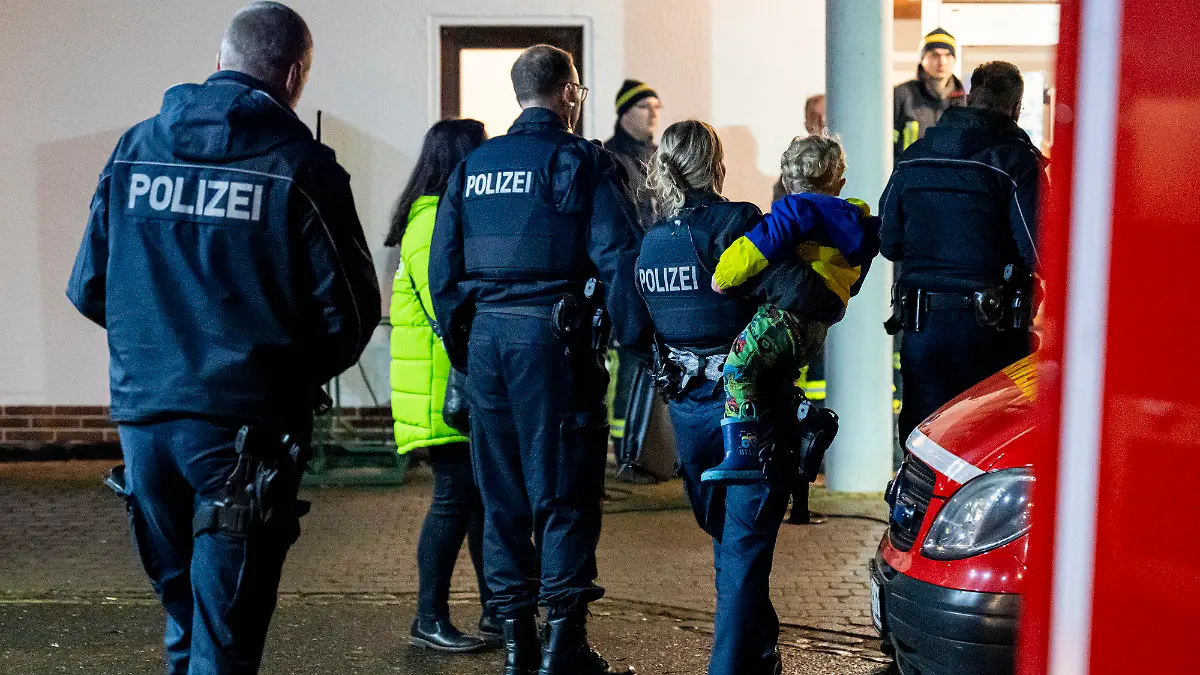 04.02.2024, Hessen, Oberellenbach: Eine Polzistin trägt den gesuchten Zweijährigen auf dem Arm, nachdem er gefunden wurde. Der im hessischen Oberellenbach entwischte Zweijährige ist leicht unterkühlt, aber unverletzt gefunden worden. Polizei und Rettungskräfte hatten den Jungen seit Sonntagnachmittag gesucht, gegen 23.30 Uhr sei er in der Nähe einer Landstraße entdeckt worden, sagte ein Sprecher der Polizei. Foto: Jacob Schröter/dpa +++ dpa-Bildfunk +++