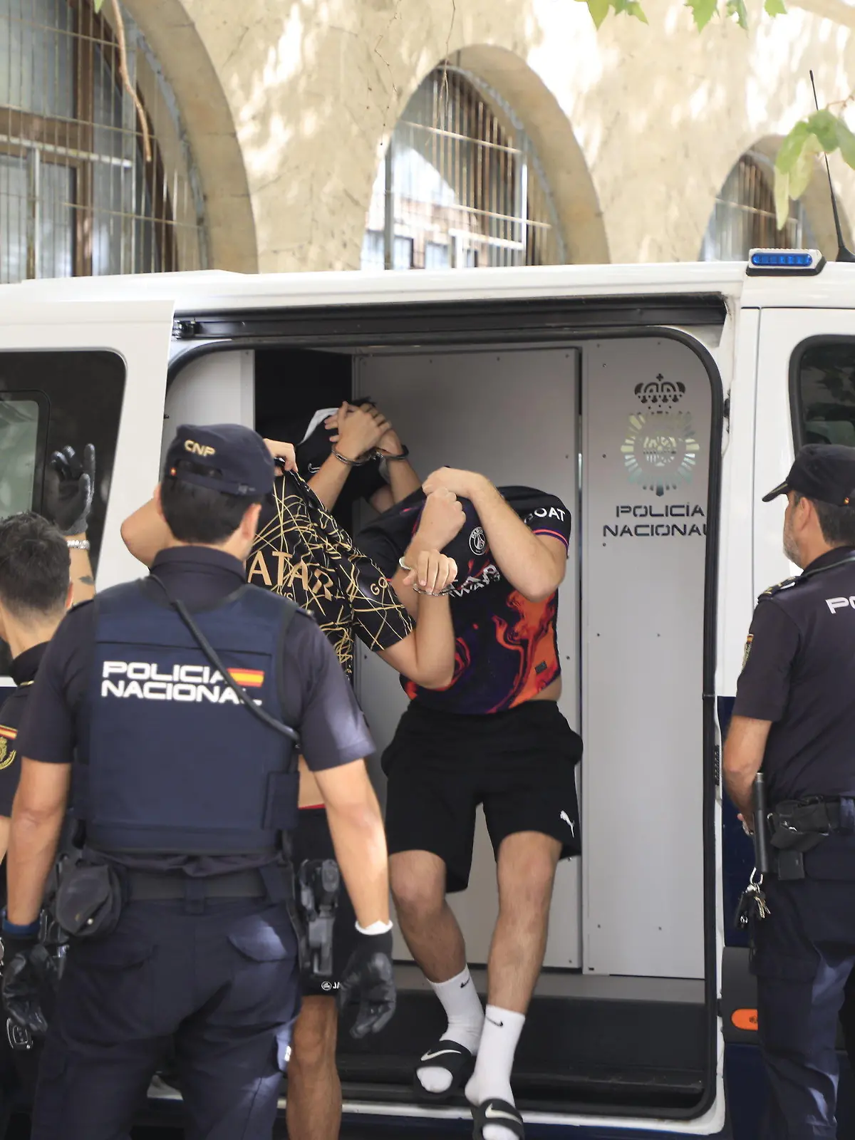 15.07.2023, Spanien, Palma de Mallorca: Polizisten führen die Verdächtigen zum Termin mit dem Haftrichter auf der Balearische Insel. Gegen sechs Urlauber aus Deutschland sind auf Mallorca schwere Vorwürfe erhoben worden. Die Polizei ermittelt wegen einer Gruppenvergewaltigung. Ein Richter entscheidet nun, ob die Männer in Untersuchungshaft müssen. Foto: Clara Margais/dpa +++ dpa-Bildfunk +++