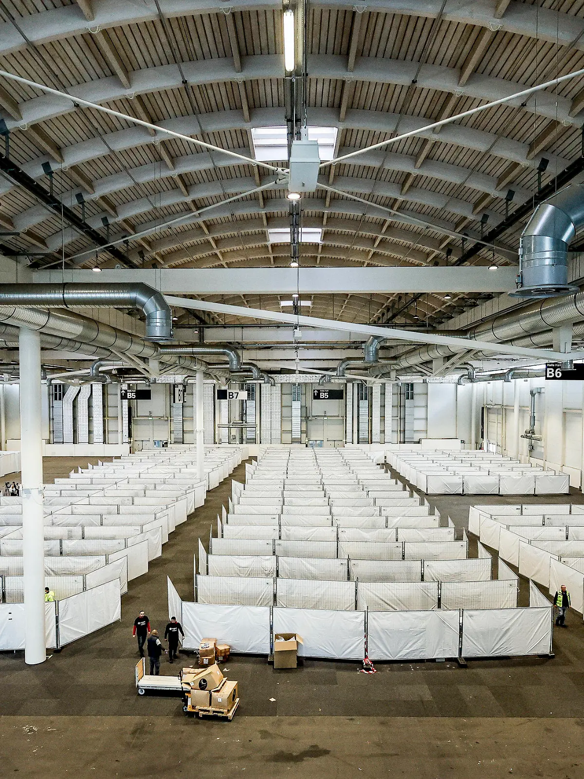 09.10.2022, Hamburg: Arbeiter bereiten eine Messehalle für die Unterbringung von Schutzsuchenden aus der Ukraine vor. Die Halle soll kurzfristig mit rund 400 Menschen belegt werden. Foto: Axel Heimken/dpa +++ dpa-Bildfunk +++