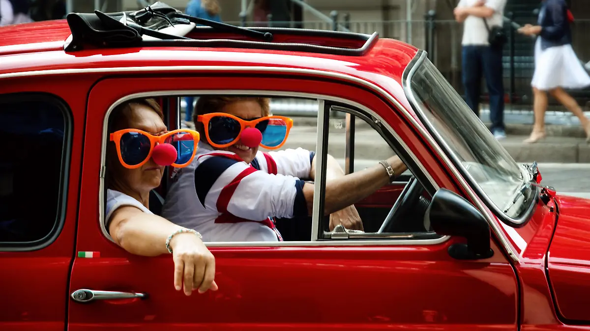 Turin, Italy - September 24, 2017 - Funny looking couple driving an old red Fiat 500 during a classic car rally in Turin (Italy) on september 24, 2017