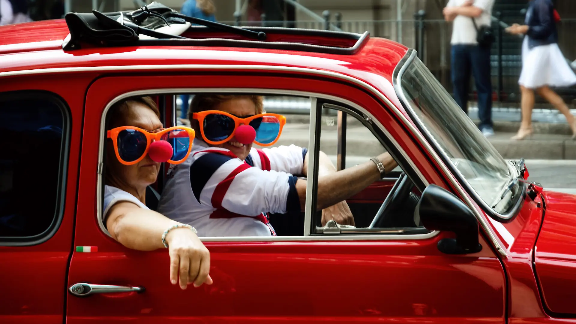 Turin, Italy - September 24, 2017 - Funny looking couple driving an old red Fiat 500 during a classic car rally in Turin (Italy) on september 24, 2017