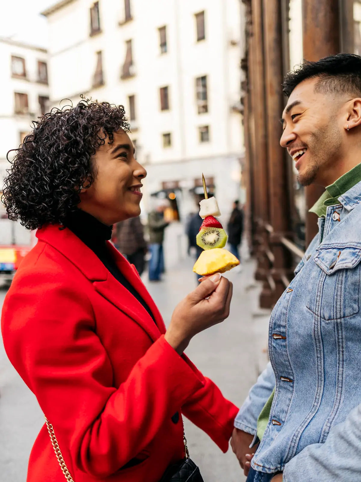 young couples in a relationship on the city street enjoying a fruit dessert on their Valentine's date.