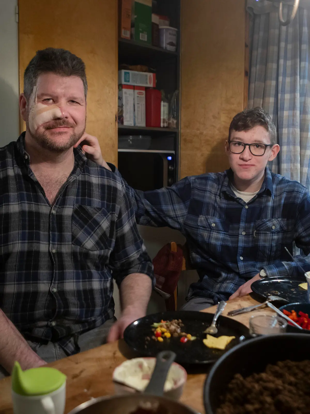 RAMSJÖ 20240202 Pär Sundström, 42, blev attackerad av en björn under en jakt i höstas. Sonen Evert, 15, räddade hans liv genom att slå björnen i huvudet. Pär fördes till sjukhuset där han opererades. Nu ligger björnen i frysen och har använts till många olika kötträtter, bland annat tacos. Till sommaren ska han få hem björnfällen. Bilden: Pär tillsammans med sonen Evert. Foto: Mats Anderssson / Aftonbladet / TT kod 85093 *** EXPRESSEN OUT ***