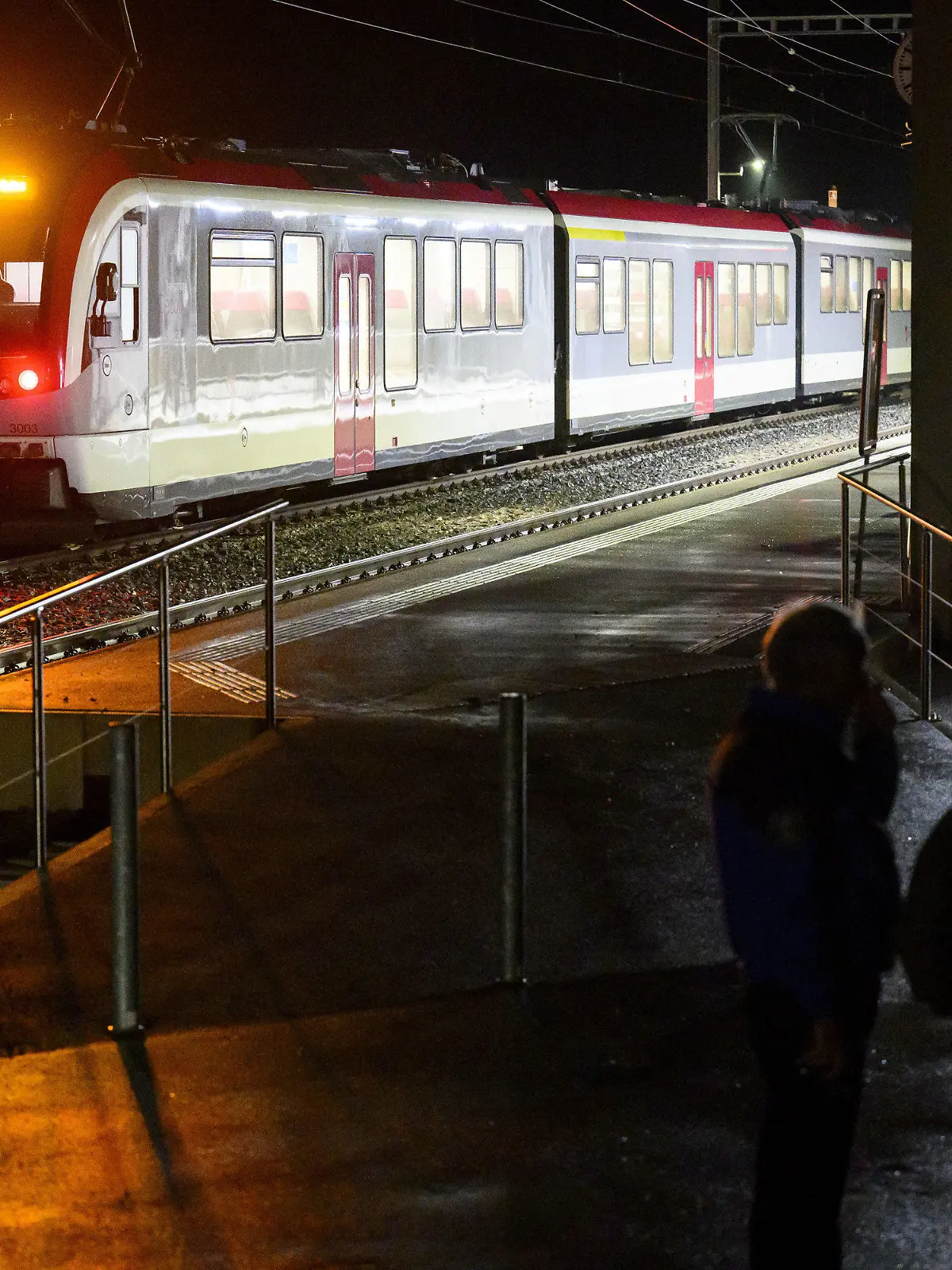 08.02.2024, Schweiz, Essert-Sous-Champvent: Waadtländer Kantonspolizisten bewachen den Travys-Zug, in dem sich eine Geiselnahme ereignet hat. In der Schweiz ist es am Donnerstag in einem Regionalzug zu einer Geiselnahme gekommen. Nach Angaben der Polizei konnten alle Geiseln befreit werden und waren wohlauf. Der Zwischenfall ereignete sich in der Westschweiz zwischen Yverdon und Sainte-Croix. Foto: Laurent Gillieron/KEYSTONE/dpa +++ dpa-Bildfunk +++