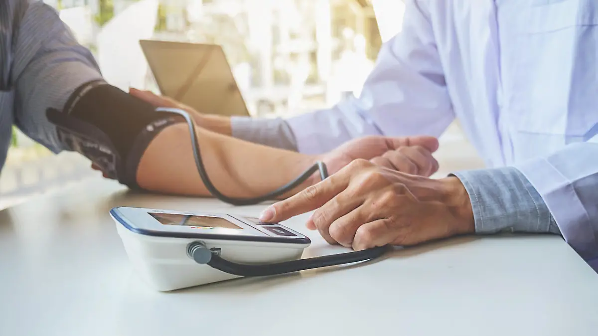 healthcare, hospital and medicine concept - doctor and patient measuring blood pressure.