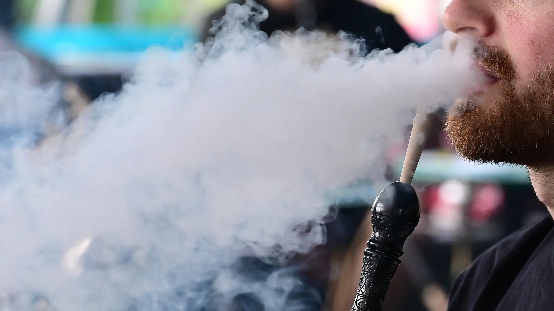 ARCHIV - 29.06.2023, Baden-Württemberg, Sindelfingen: Ein Mann raucht in einer Shisha-Bar eine Shisha-Wasserpfeife. (zu dpa: «Shisha-Branche befürchtet Pleitewelle») Foto: Bernd Weißbrod/dpa +++ dpa-Bildfunk +++