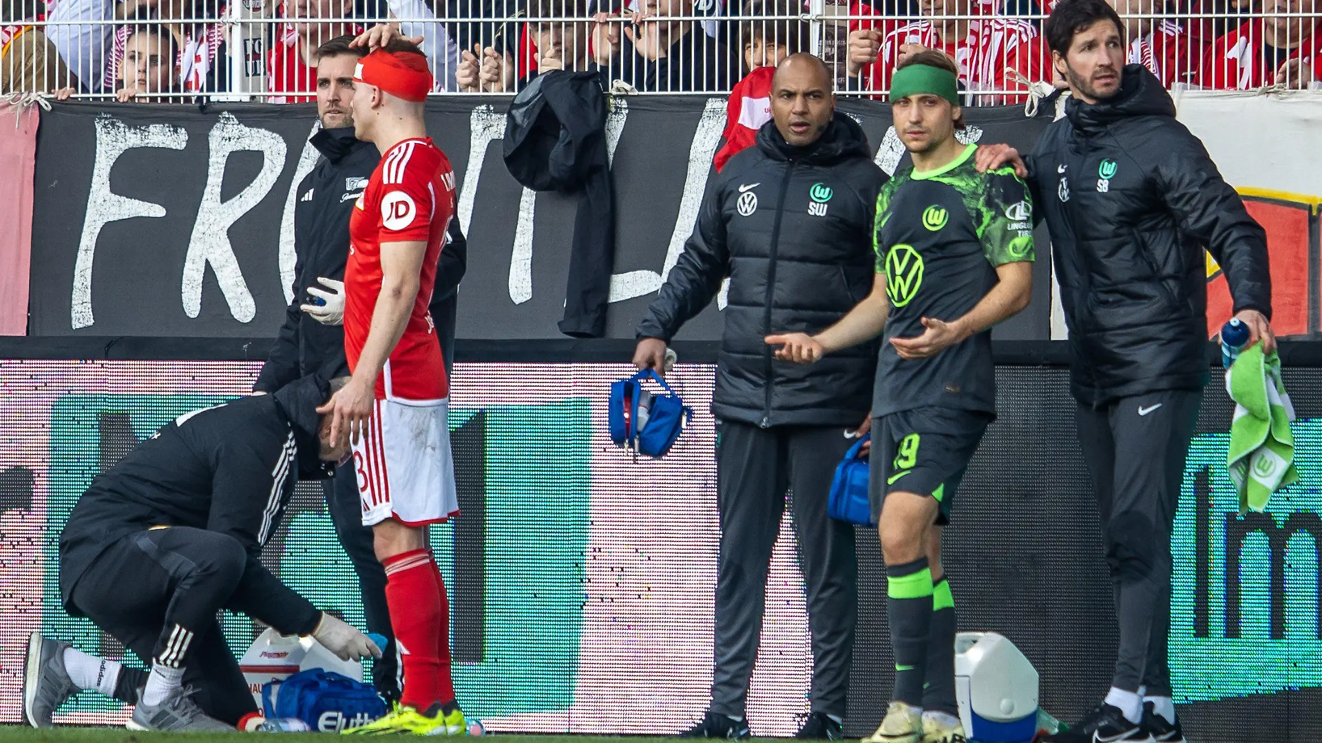 10.02.2024, Berlin: Fußball: Bundesliga, 1. FC Union Berlin - VfL Wolfsburg, 21. Spieltag, An der Alten Försterei. Berlins Andras Schäfer und Lovro Majer (2.v.r) von VfL Wolfsburg sind mit den Köpfen zusammengestossen. Foto: Andreas Gora/dpa - WICHTIGER HINWEIS: Gemäß den Vorgaben der DFL Deutsche Fußball Liga bzw. des DFB Deutscher Fußball-Bund ist es untersagt, in dem Stadion und/oder vom Spiel angefertigte Fotoaufnahmen in Form von Sequenzbildern und/oder videoähnlichen Fotostrecken zu verwerten bzw. verwerten zu lassen. +++ dpa-Bildfunk +++