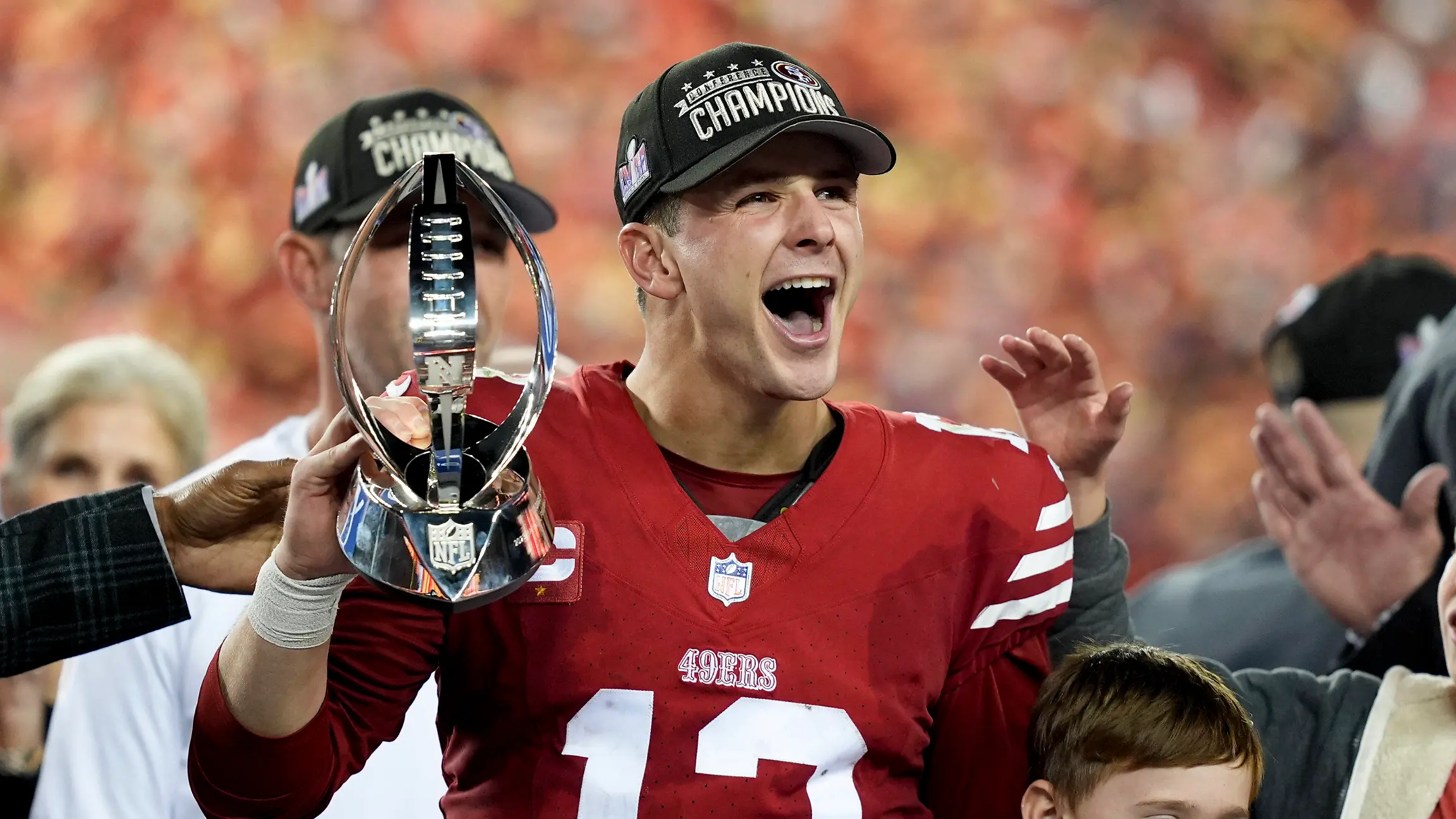 ARCHIV - 28.01.2024, USA, Santa Clara: American Football: Profiliga NFL, San Francisco 49ers - Detroit Lions; NFC Championship; Play-off-Runde, Halbfinale: San Francisco 49ers Quarterback Brock Purdy feiert mit der Trophäe nach dem Sieg. (zu dpa: «Groß, größer, Super Bowl in Las Vegas: NFL vor XXL-Spektakel») Foto: David J. Phillip/AP/dpa +++ dpa-Bildfunk +++