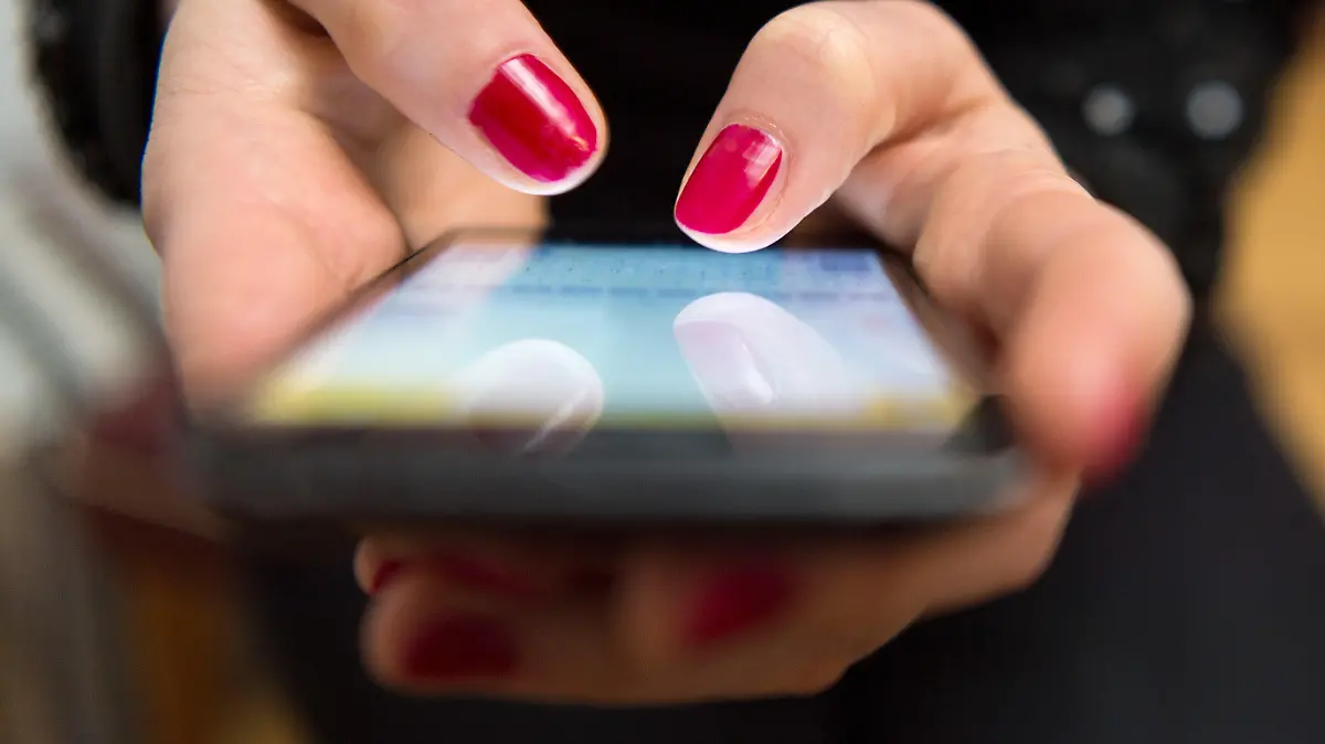 ARCHIV - 28.03.2017, NA, Berlin: ILLUSTRATION - Eine Frau tippt auf einem Smartphone. Ein Mann aus Bremervörde hat durch sogenanntes Love-Scamming 60 000 Euro verloren. (zu dpa: «Verliebter Mann verliert 60 000 Euro durch Betrug») Foto: Sebastian Gollnow/dpa +++ dpa-Bildfunk +++