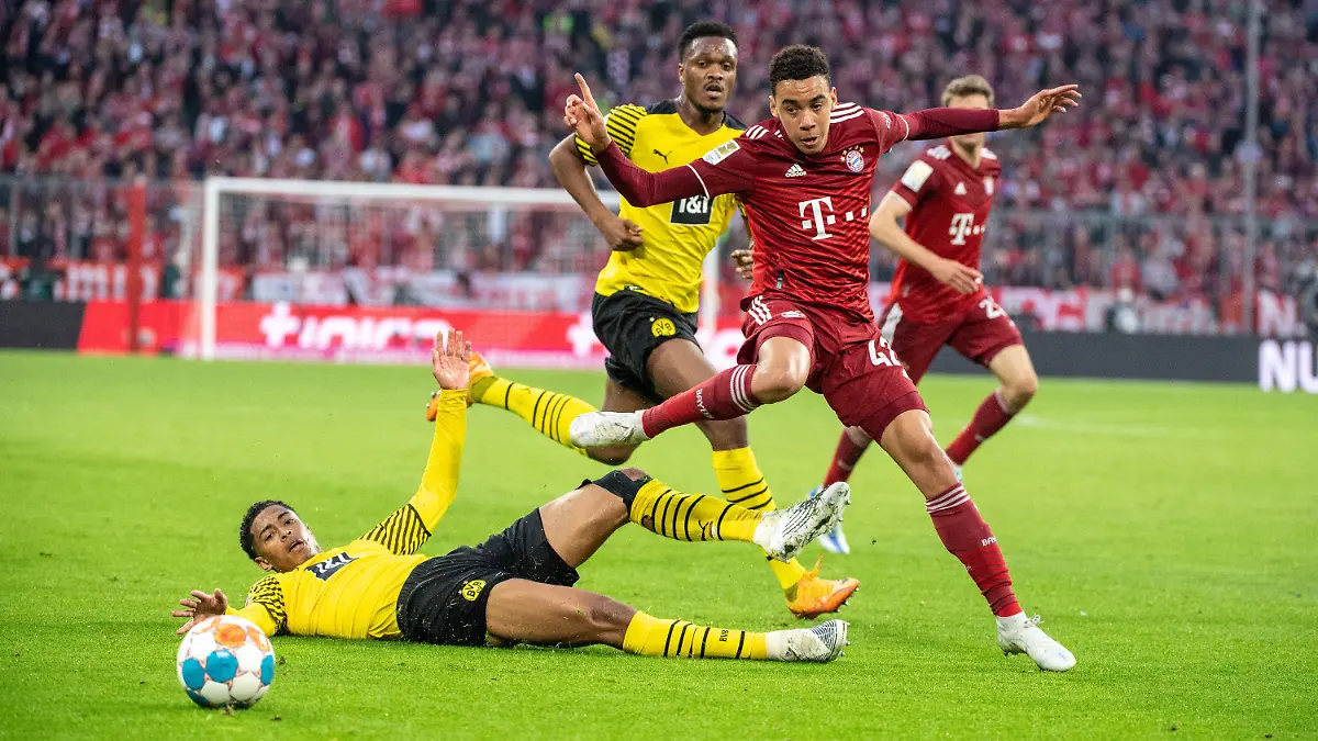 23.04.2022, Bayern, München: Fußball: Bundesliga, Bayern München - Borussia Dortmund, 31. Spieltag, Allianz Arena. Dan-Axel Zagadou von Borussia Dortmund (M), Jamal Musiala vom FC Bayern München (r) und Jude Bellingham von Borussia Dortmund (unten) kämpfen um den Ball. (zu dpa: «Nagelsmann über Musiala und Bellingham: Können uns alle freuen») Foto: Matthias Balk/dpa +++ dpa-Bildfunk +++
