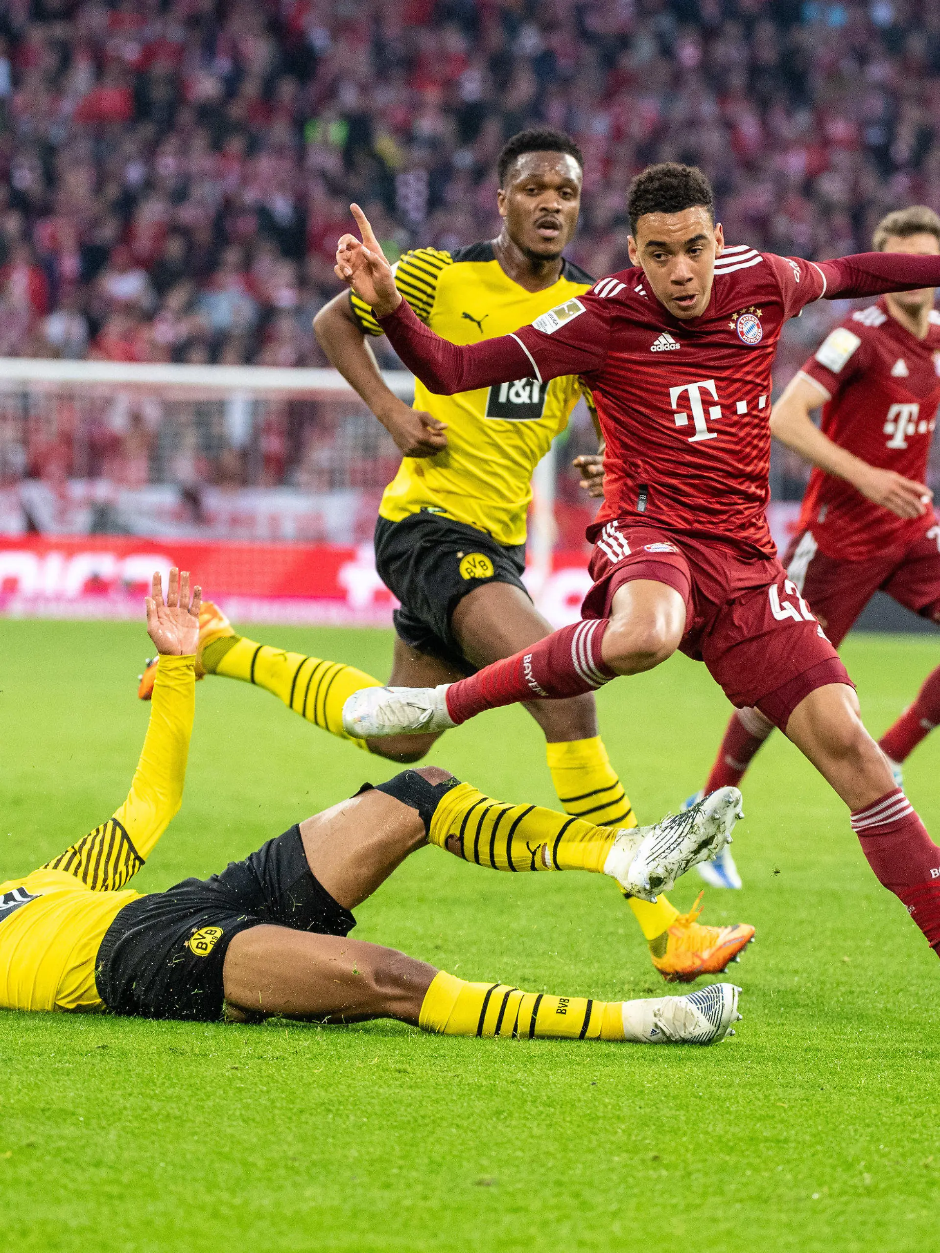 23.04.2022, Bayern, München: Fußball: Bundesliga, Bayern München - Borussia Dortmund, 31. Spieltag, Allianz Arena. Dan-Axel Zagadou von Borussia Dortmund (M), Jamal Musiala vom FC Bayern München (r) und Jude Bellingham von Borussia Dortmund (unten) kämpfen um den Ball. (zu dpa: «Nagelsmann über Musiala und Bellingham: Können uns alle freuen») Foto: Matthias Balk/dpa +++ dpa-Bildfunk +++