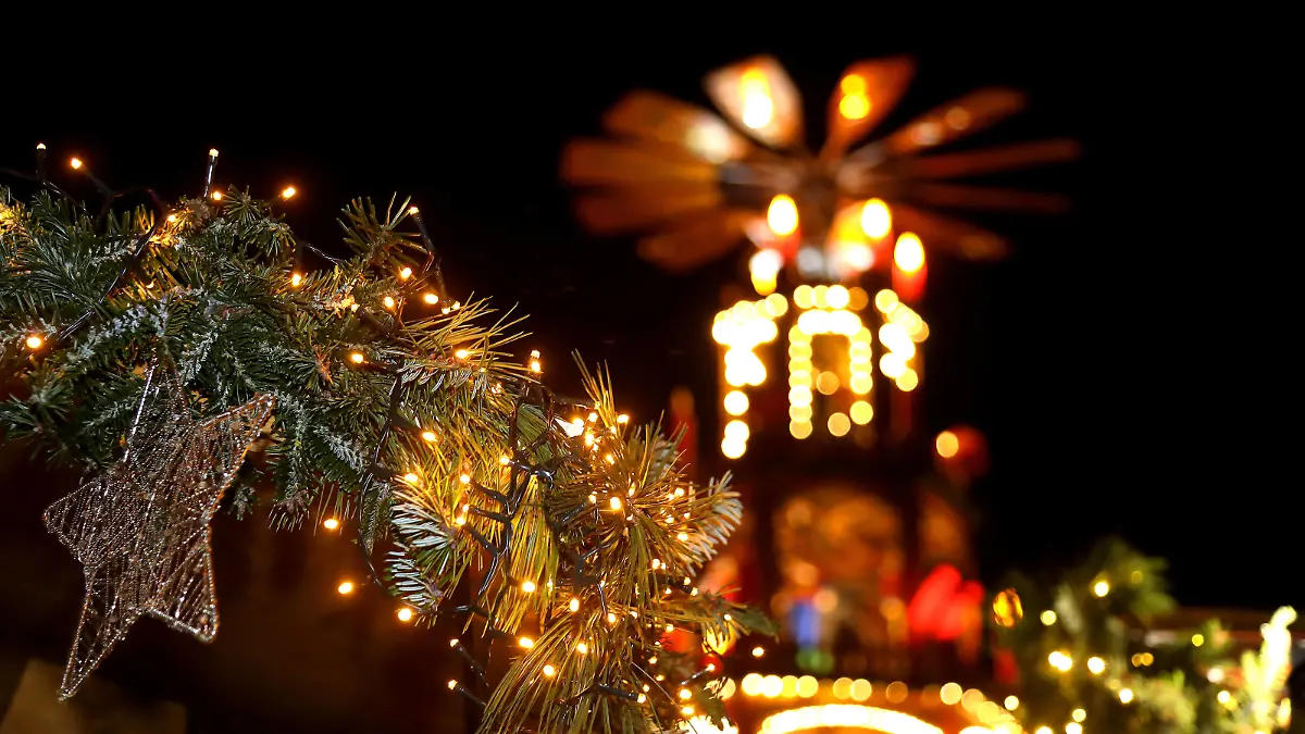  Weihnachtsmarkt - GER, Germany, Deutschland, Fulda, 20.12.2021 - Fulda: Weihnachtsmarkt in den Abendstunden der Vorweihnachtszeit im Zentrum in der Barockstadt. Weihnachtsstern mit Weihnachtsgirlande an einem Verkaufsstand vor der illuminierten Weihnachtspyramide. *** Christmas market GER, Germany, Deutschland, Fulda, 20 12 2021 Fulda Christmas market in the evening hours of the pre-Christmas period in the center in the baroque city Christmas star with Christmas garland at a sales stand in front of the illuminated Christmas pyramid