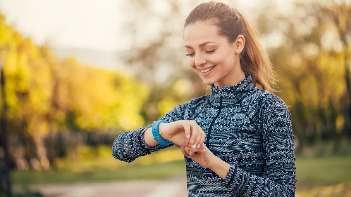 Sportswoman looking at her smart watch in the park.