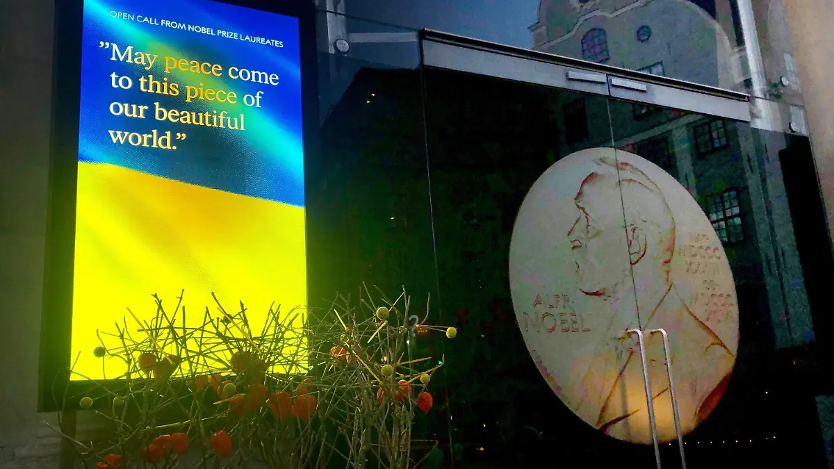 06.10.2022, Schweden, Stockholm: Auf einem Bildschirm vor dem Nobelpreismuseum in Stockholm ist eine Ukraine-Flagge zu sehen mit dem Schriftzug "May peace come to this piece of our beautiful world". Am Vormittag wir der Friedensnobelpreisträger bekannt gegeben. Foto: Steffen Trumpf/dpa +++ dpa-Bildfunk +++